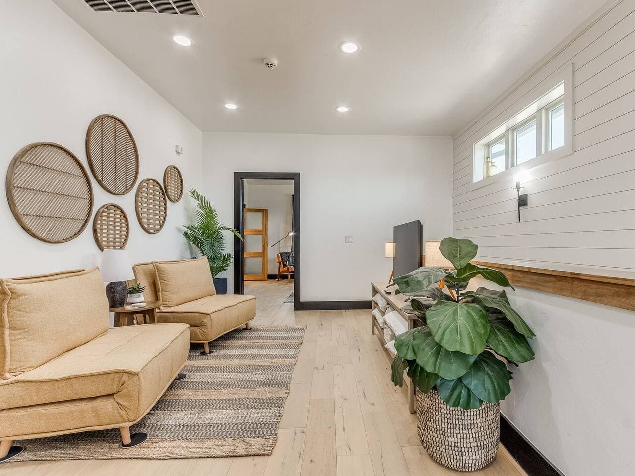 A peaceful secondary living area with comfortable furnishings, greenery, and plenty of space to unwind.
