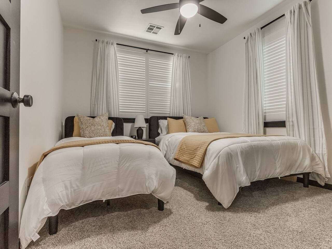 Comfortable guest bedroom with one queen bed and one single bed, ideal for families or small groups.