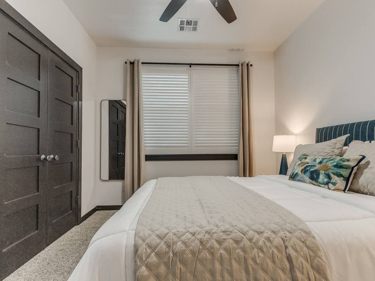 Bright and inviting bedroom with a comfortable bed, natural light, and convenient closet storage.