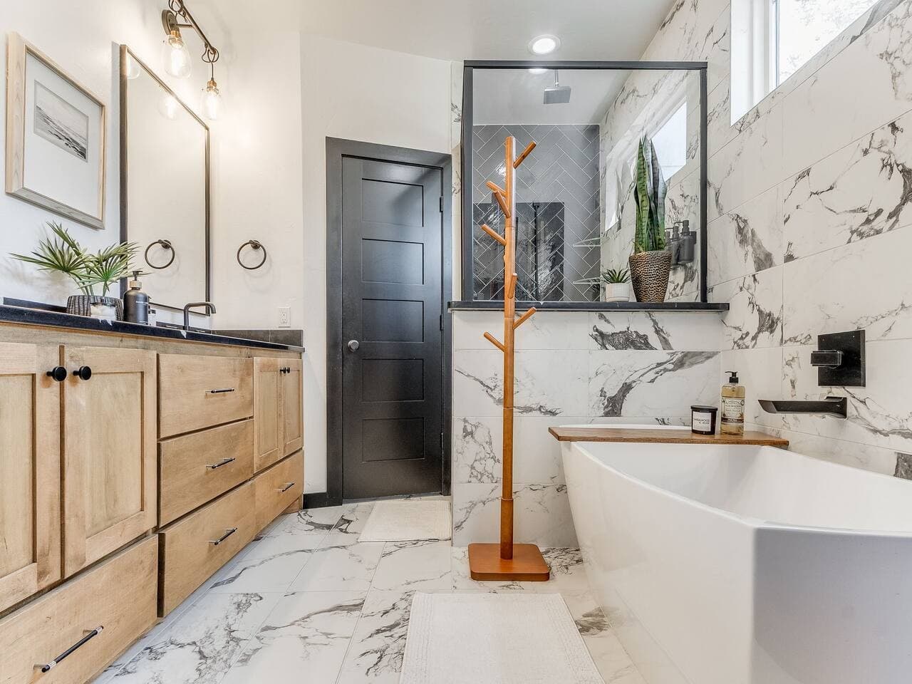Spa inspired bathroom featuring a double vanity, walk in shower, and freestanding soaking tub surrounded by beautiful marble finishes.