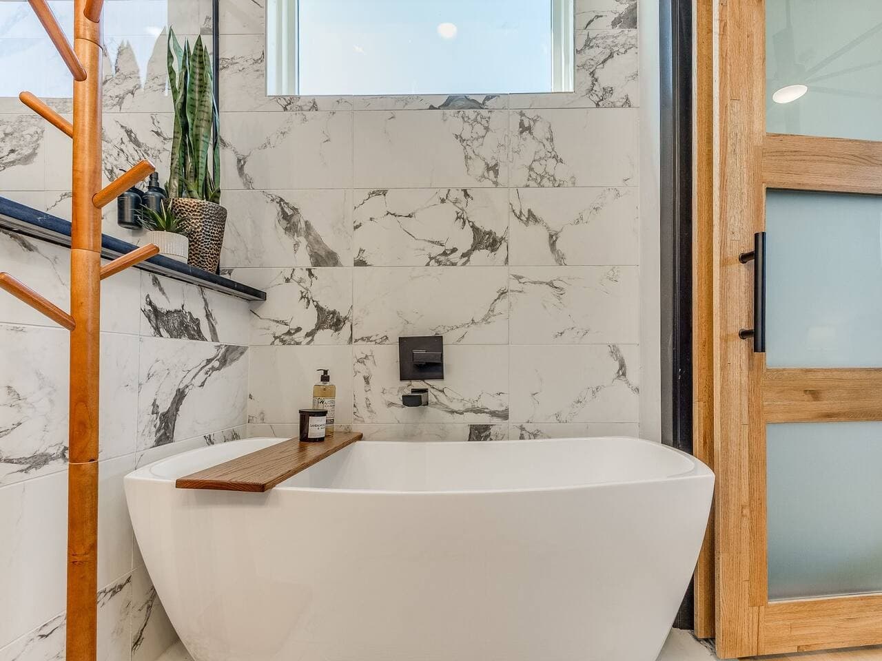 Unwind in the freestanding soaking tub surrounded by luxurious marble finishes and natural light.