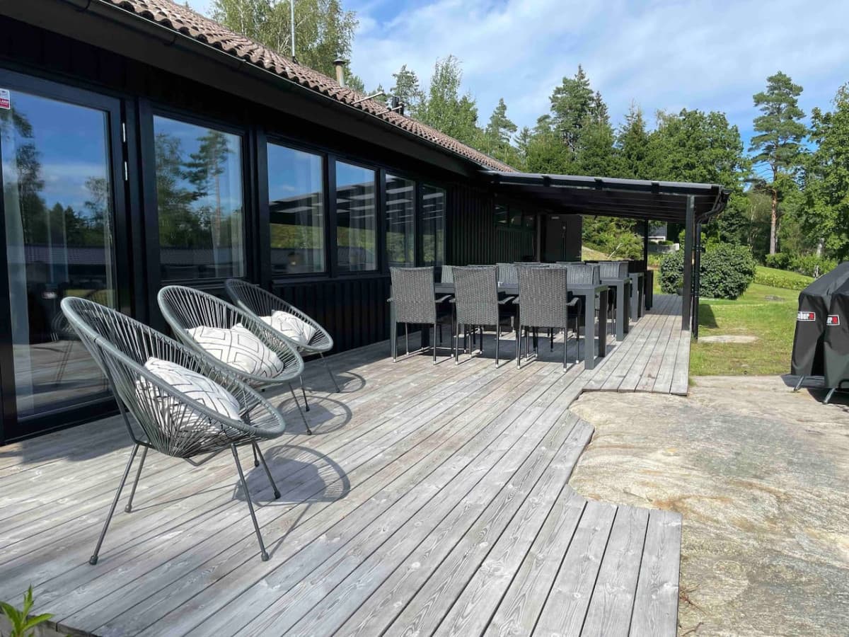 Deck by the main building with tables and chairs for 24 persons and lounge chairs
