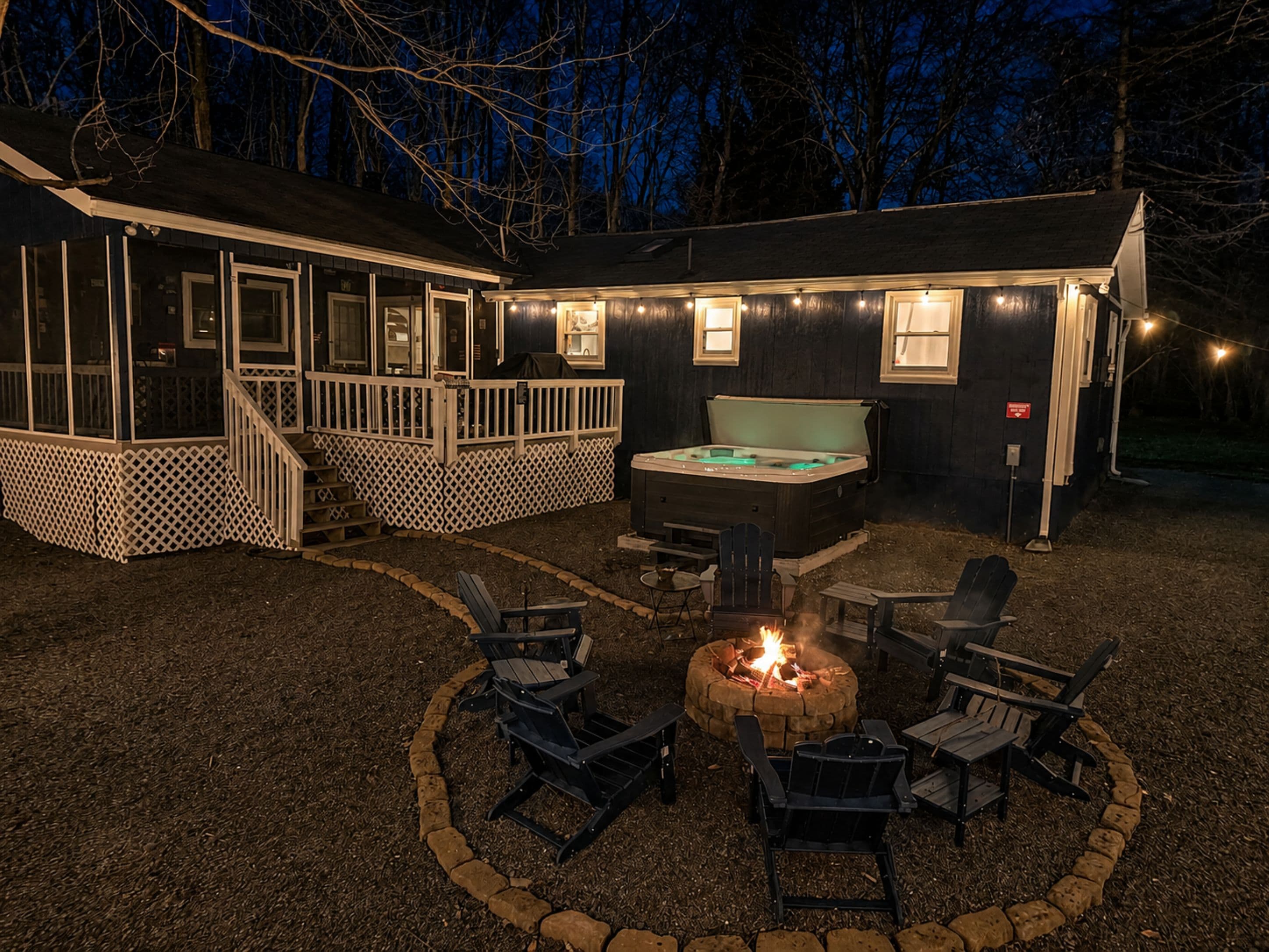 Backyard at night with firepit and hot tub