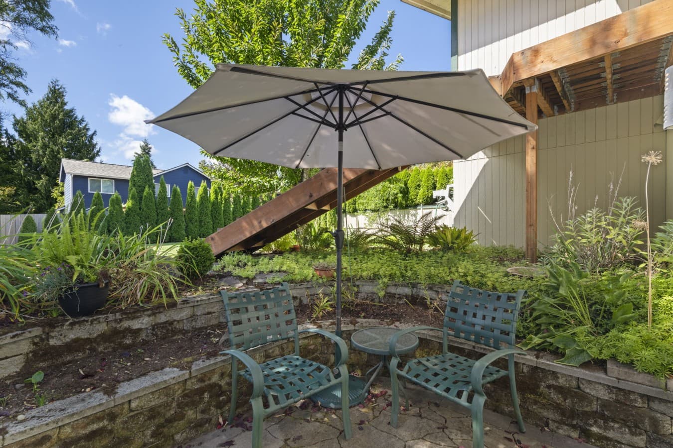 Private outdoor seating area with a table, chairs, and a large patio umbrella for shade_.jpg