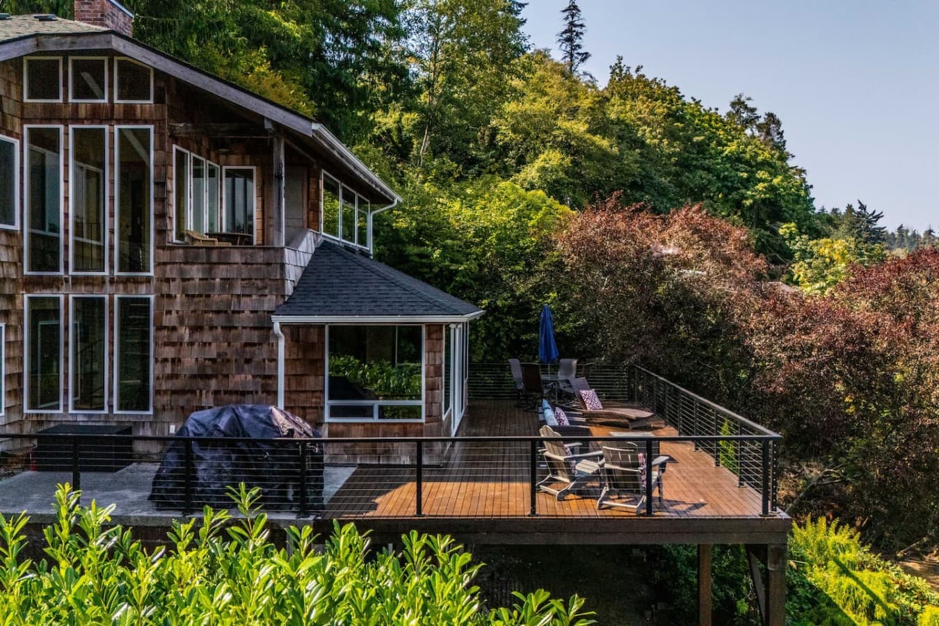 caption

A private waterfront retreat surrounded by lush greenery, with an expansive deck designed for outdoor dining, lounging, and taking in the peaceful setting.