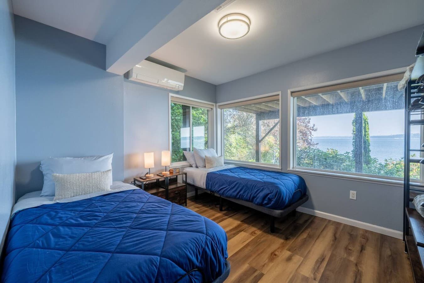 A bright and inviting bedroom with two comfortable beds and peaceful views through oversized windows