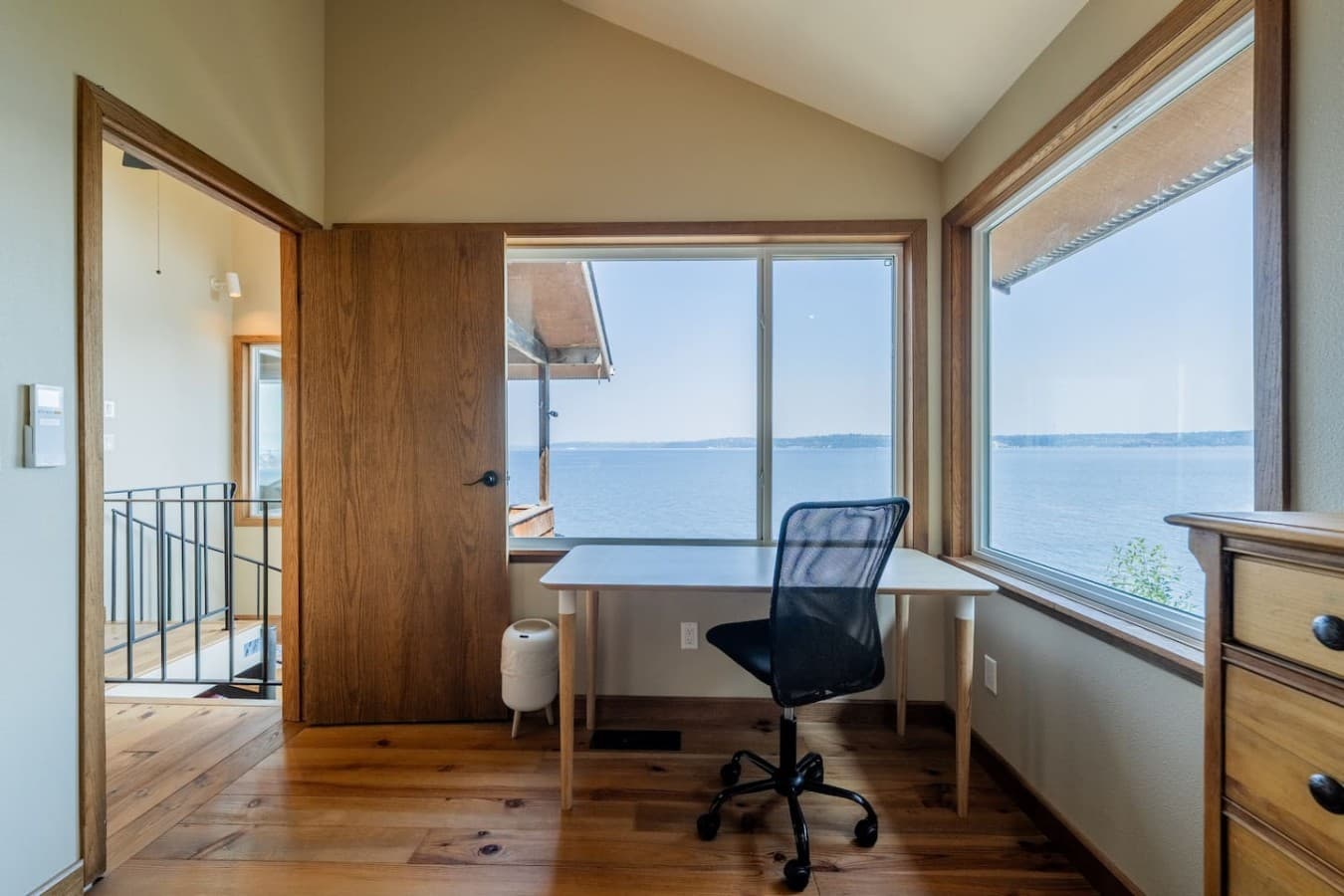 A comfortable work-from-home setup with a spacious desk, abundant natural light, and serene views outside.
