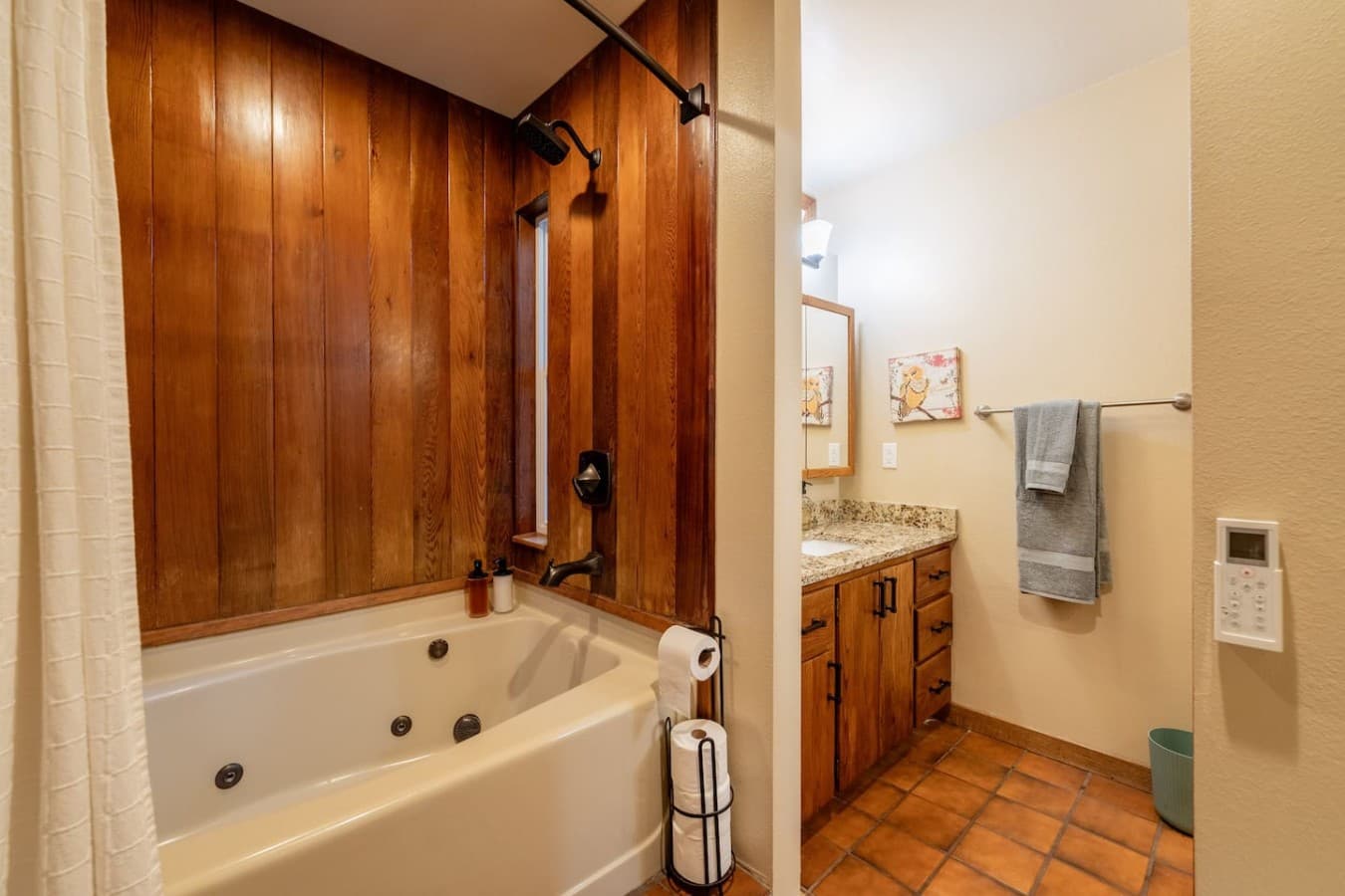 Relax and recharge in this warm, spa-inspired bathroom featuring a jetted soaking tub, rainfall shower, and natural wood accents.