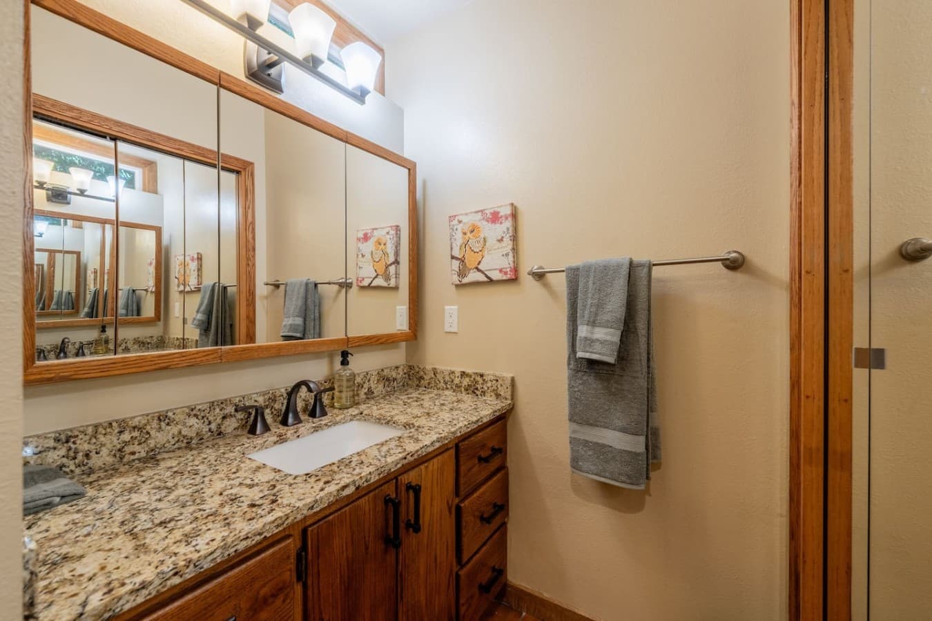 Designed for unwinding, with a jetted tub, rainfall shower, and warm wood-paneled surroundings.