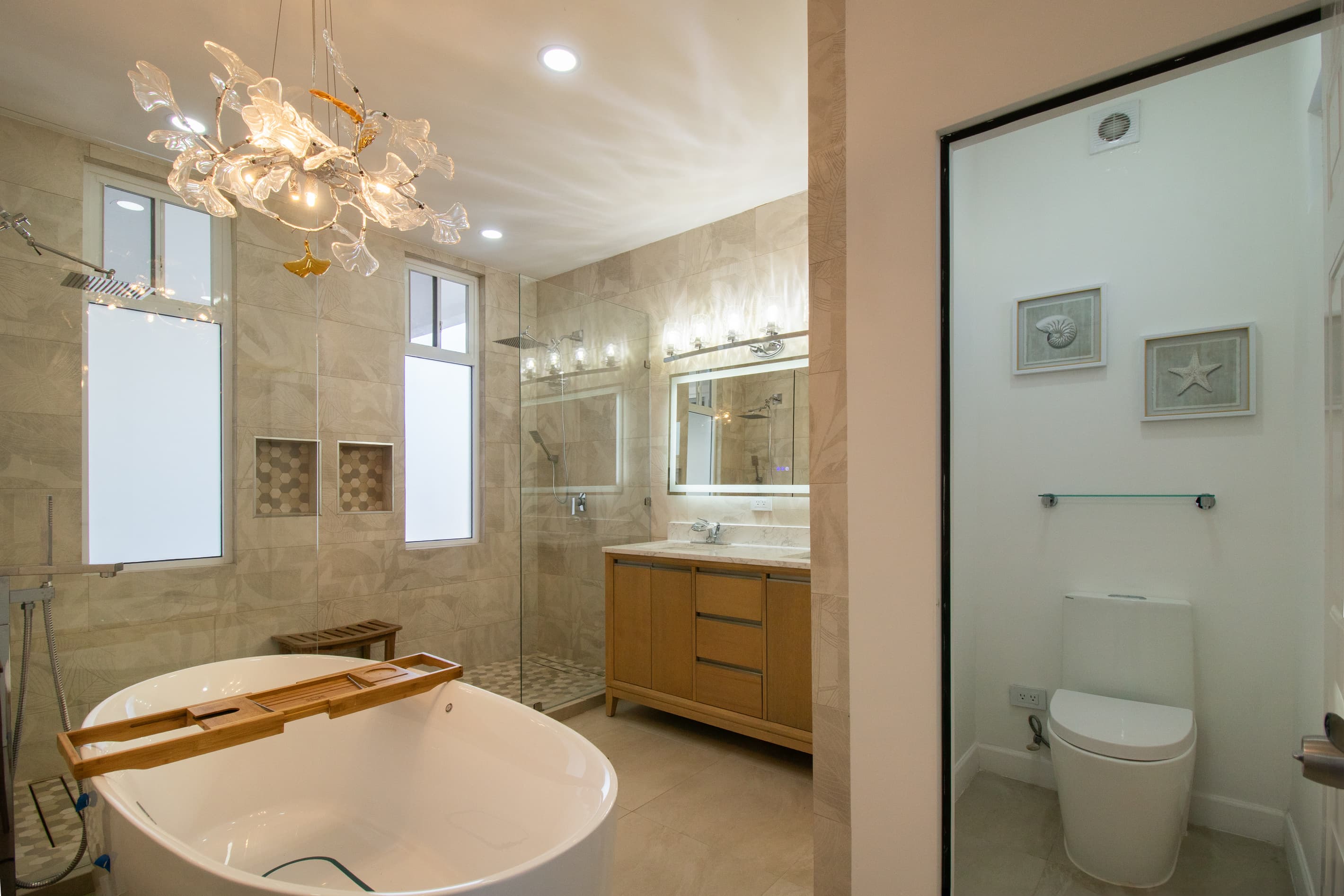 Spa-inspired primary ensuite with jetted soaking tub, dual-head shower, double vanity, and toilet room