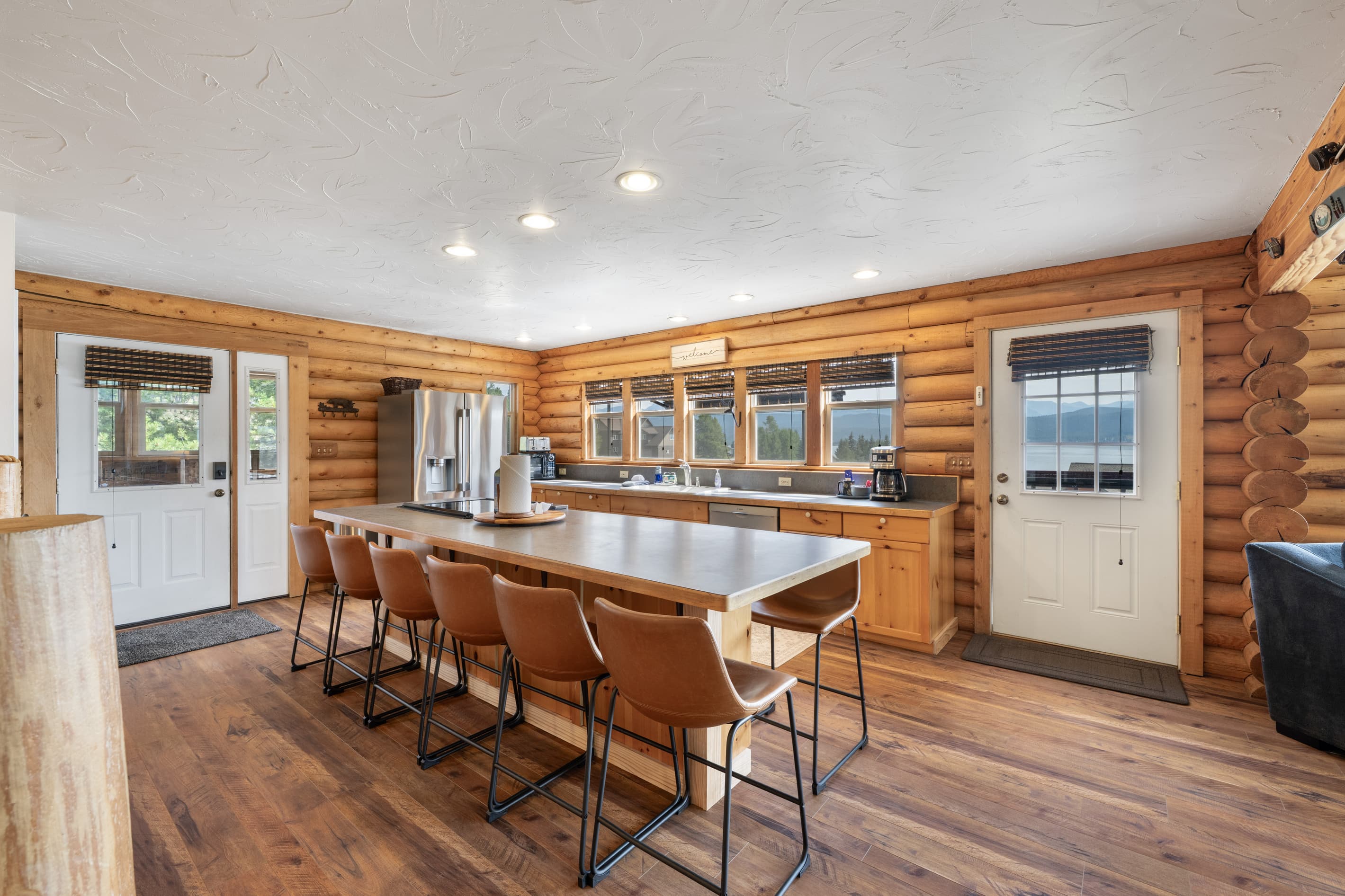 You'll enter through the door on the left side of the kitchen. Grill & deck is located out the door on the window wall. 