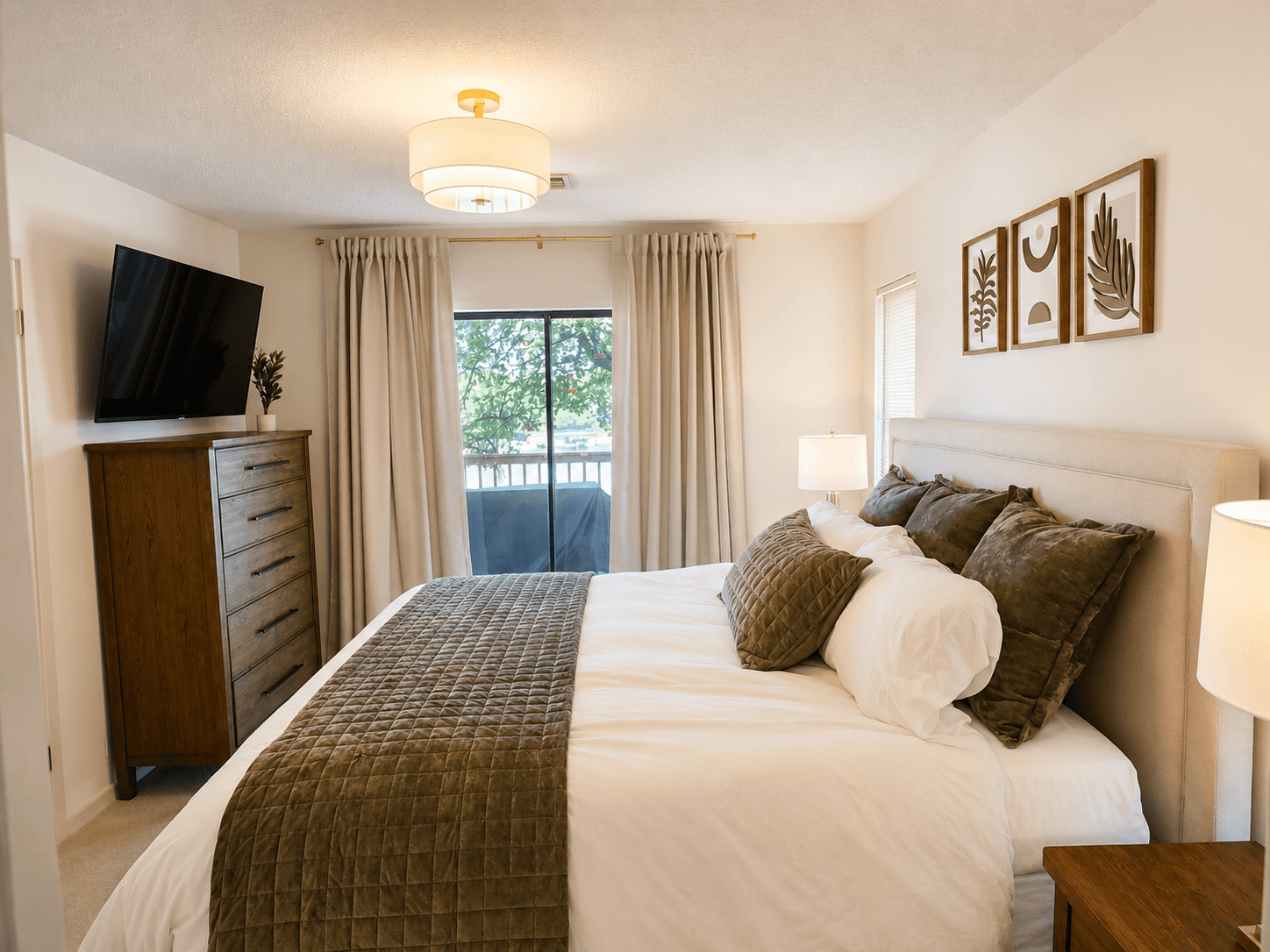 King bedroom with television, direct deck access, and lake view.