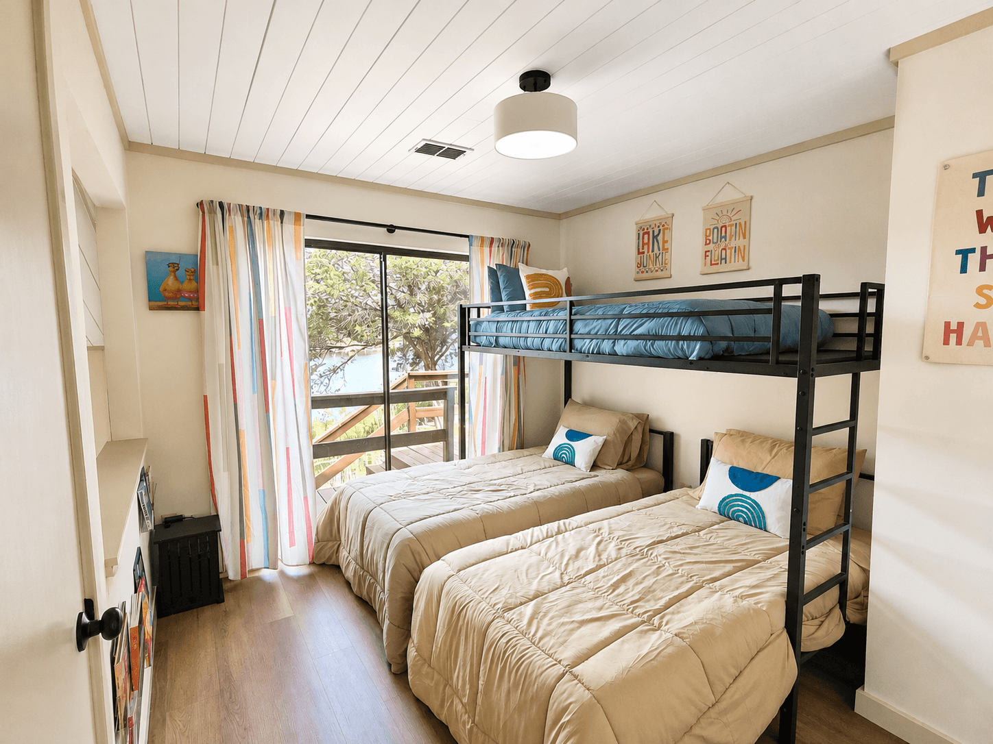 Third bedroom with a twin bunk over two twin beds, comfortably sleeping 3 guests with direct deck access and lake views.