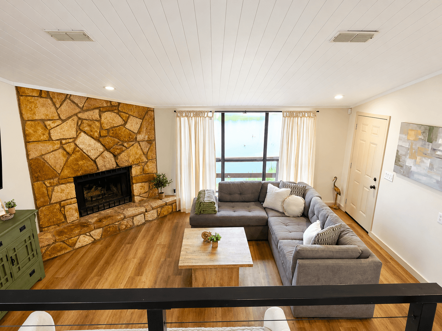 Open living room with fireplace and panoramic lake views.