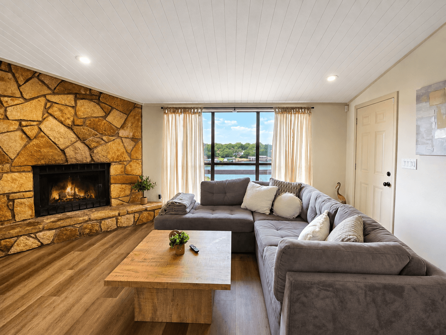 Open living room with fireplace and panoramic lake views.