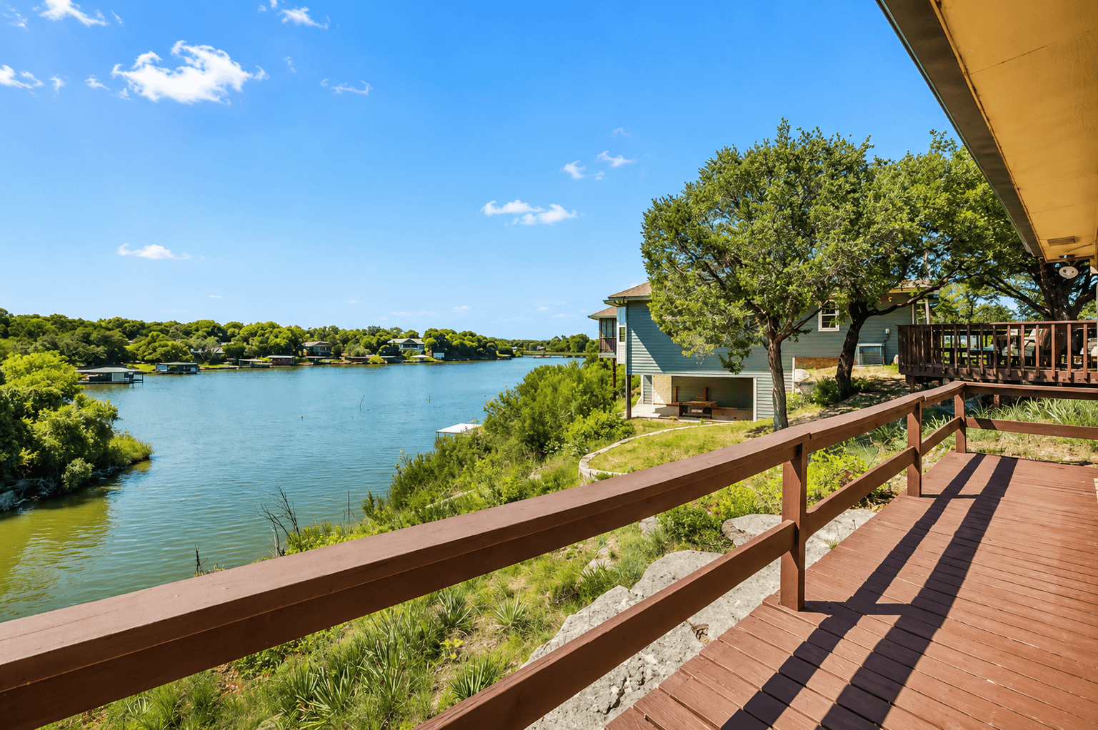 Furnished deck running along the lakeside of the home.