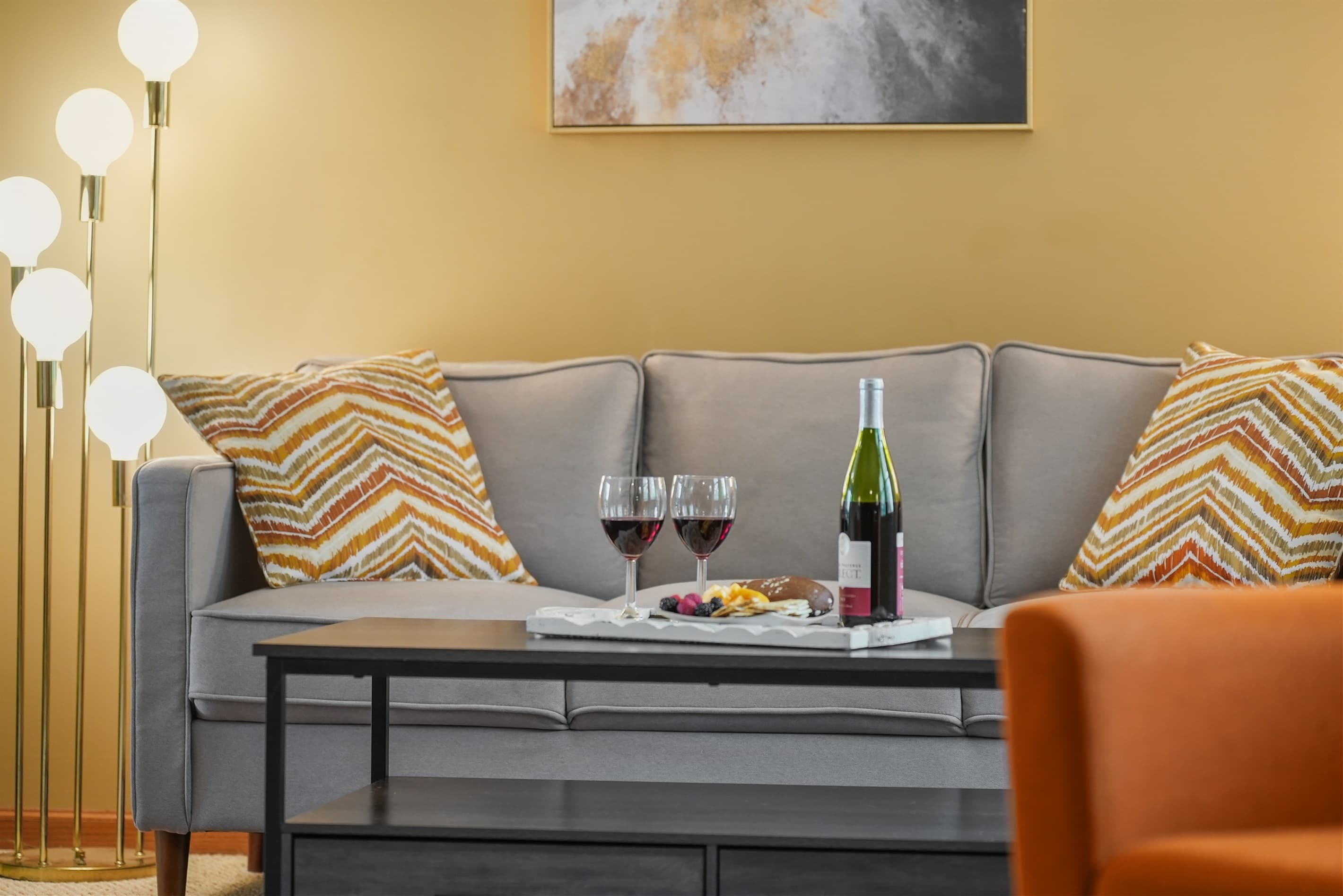 Living Room: Enjoy wine and snacks in this stylish retreat with warm lighting and vibrant decor!