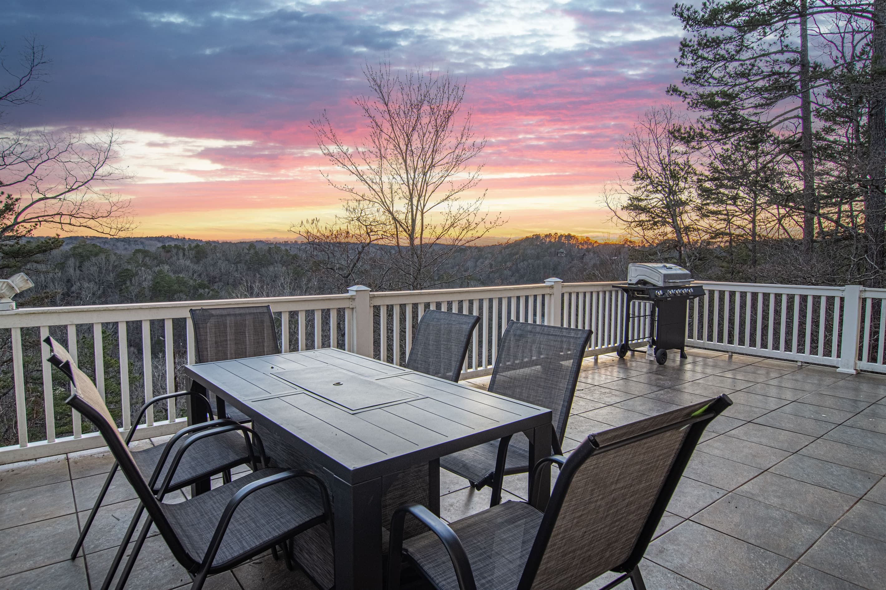 Charming views of the mountains from thePatio (lower level). Patio: Spectacular sunset views await you on this spacious deck, perfect for gatherings and grilling!
