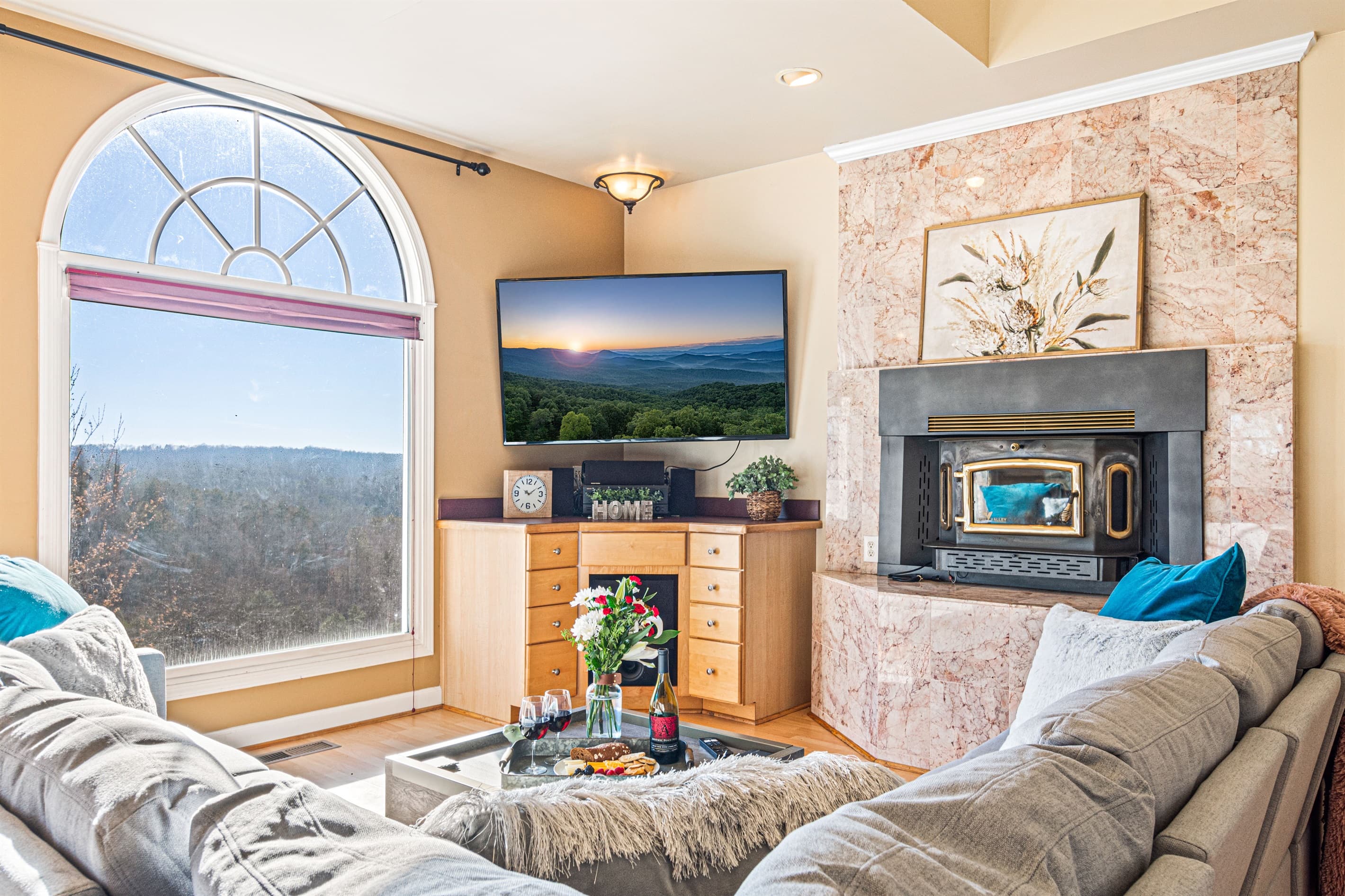 Main level living area with fireplace and flat screen TV. Living Room Oasis: Stunning views, stylish decor, and a perfect spot to unwind by the fire!