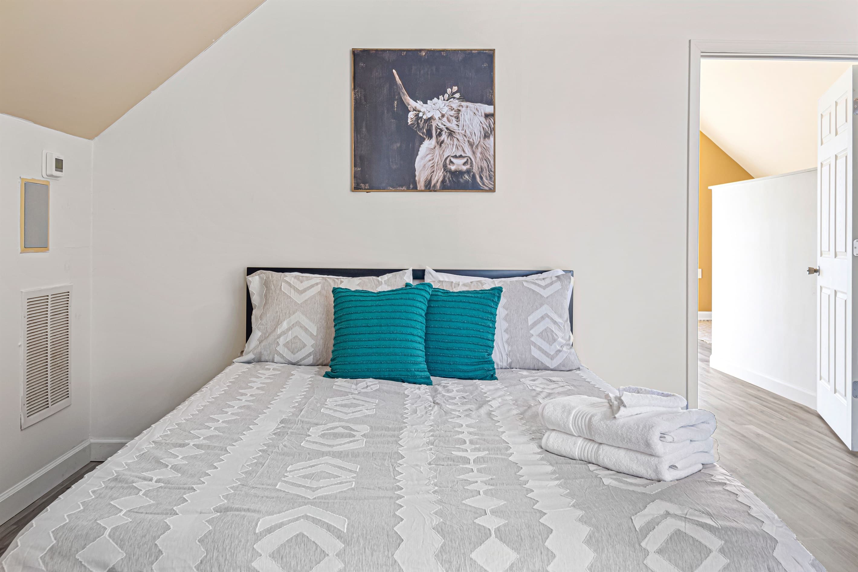 Upstairs Bedroom: Elegant queen bed with charming decor, perfect for restful nights in Ellijay!