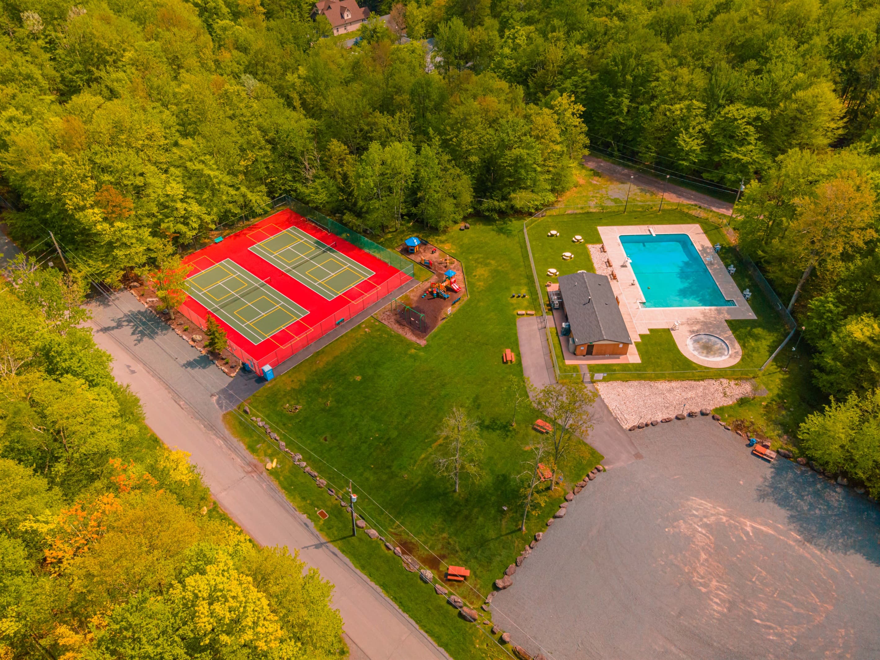 Outdoor Oasis: Dive into fun at our sparkling pool, courts, and playground amid lush greenery!