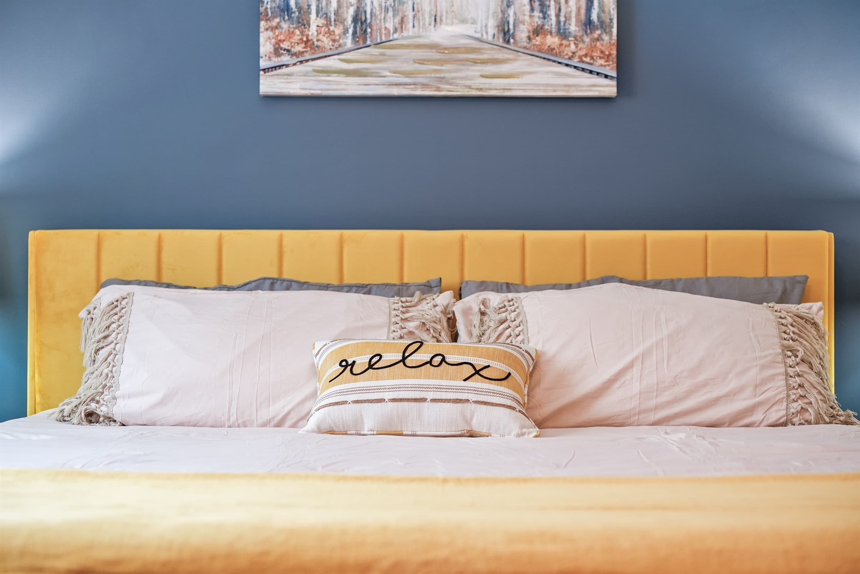 Bedroom Sanctuary: Bright yellow accents and plush pillows invite you to unwind and recharge!