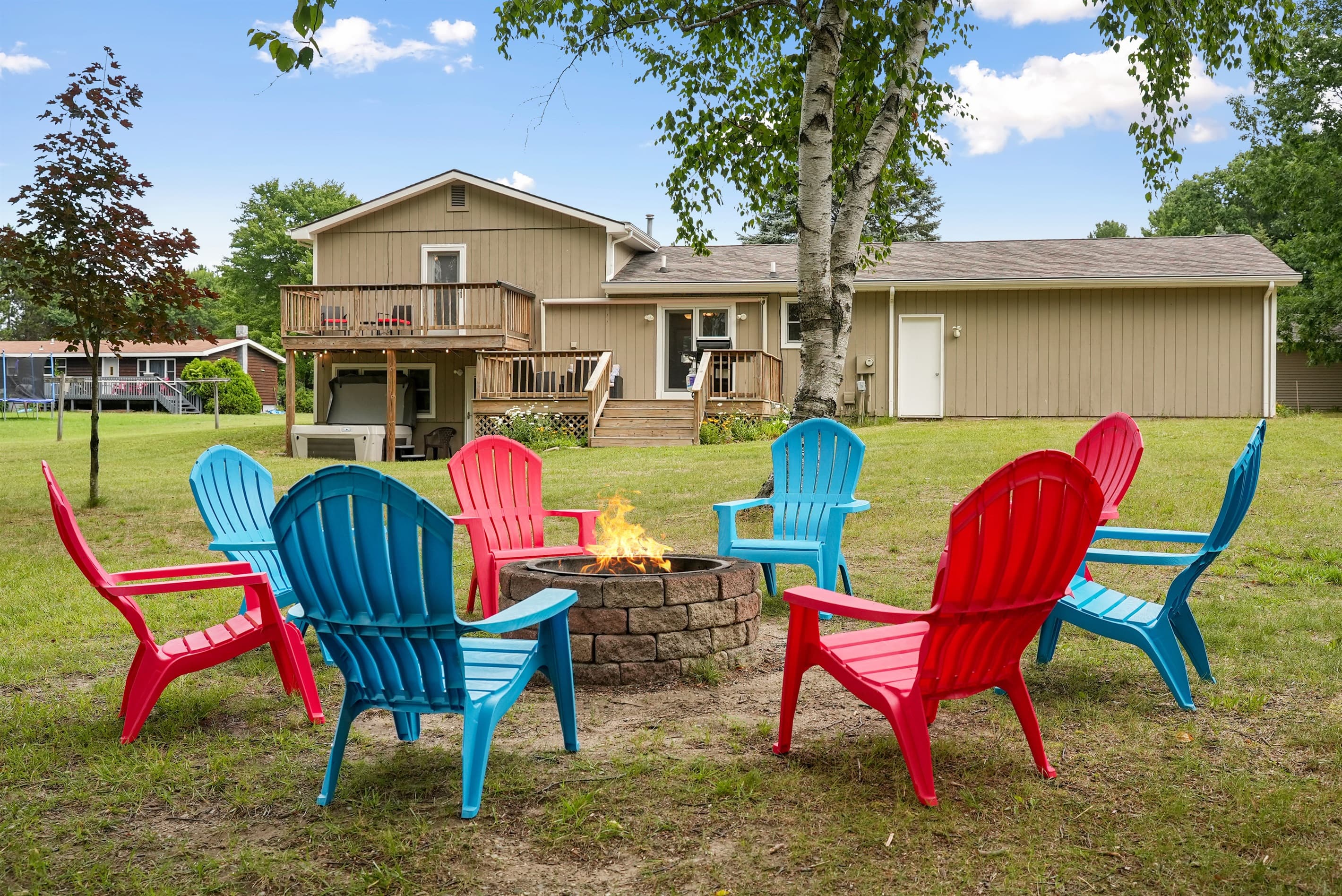 Fire pit fun: Enjoy laughter and warmth around vibrant chairs under a starlit Traverse City sky!