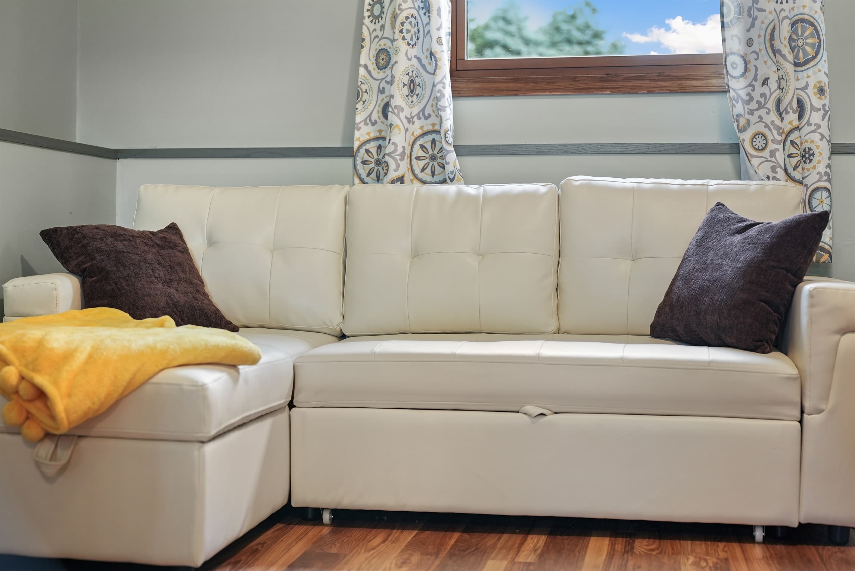 Living Room: Sink into this stylish sofa with plush pillows and a sunny view of Traverse City!