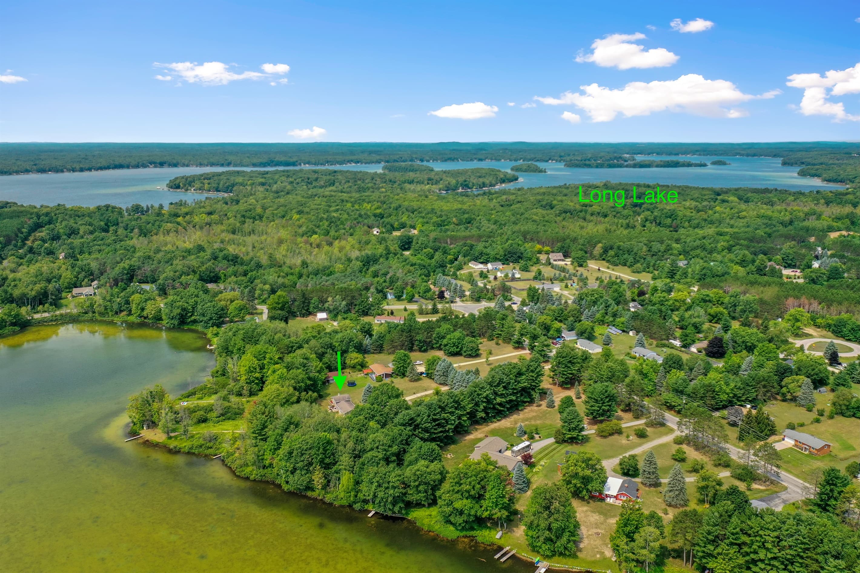 PRIVATE ACCESS TO DYER LAKE. Aerial View: Experience tranquil lakeside beauty surrounded by lush greenery in Traverse City!