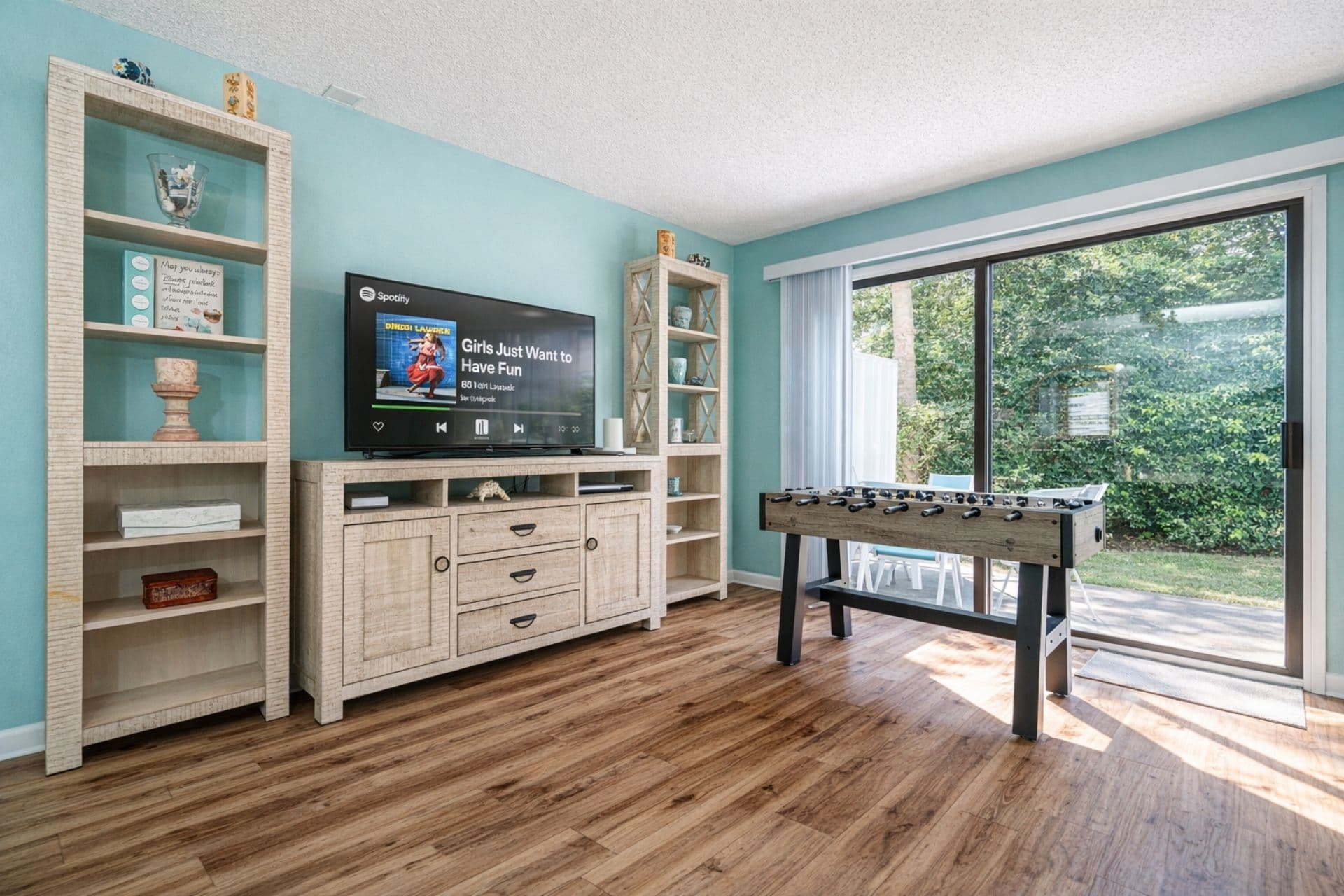 Living Room: Bright and airy space with foosball fun & views of lush palm trees outside!