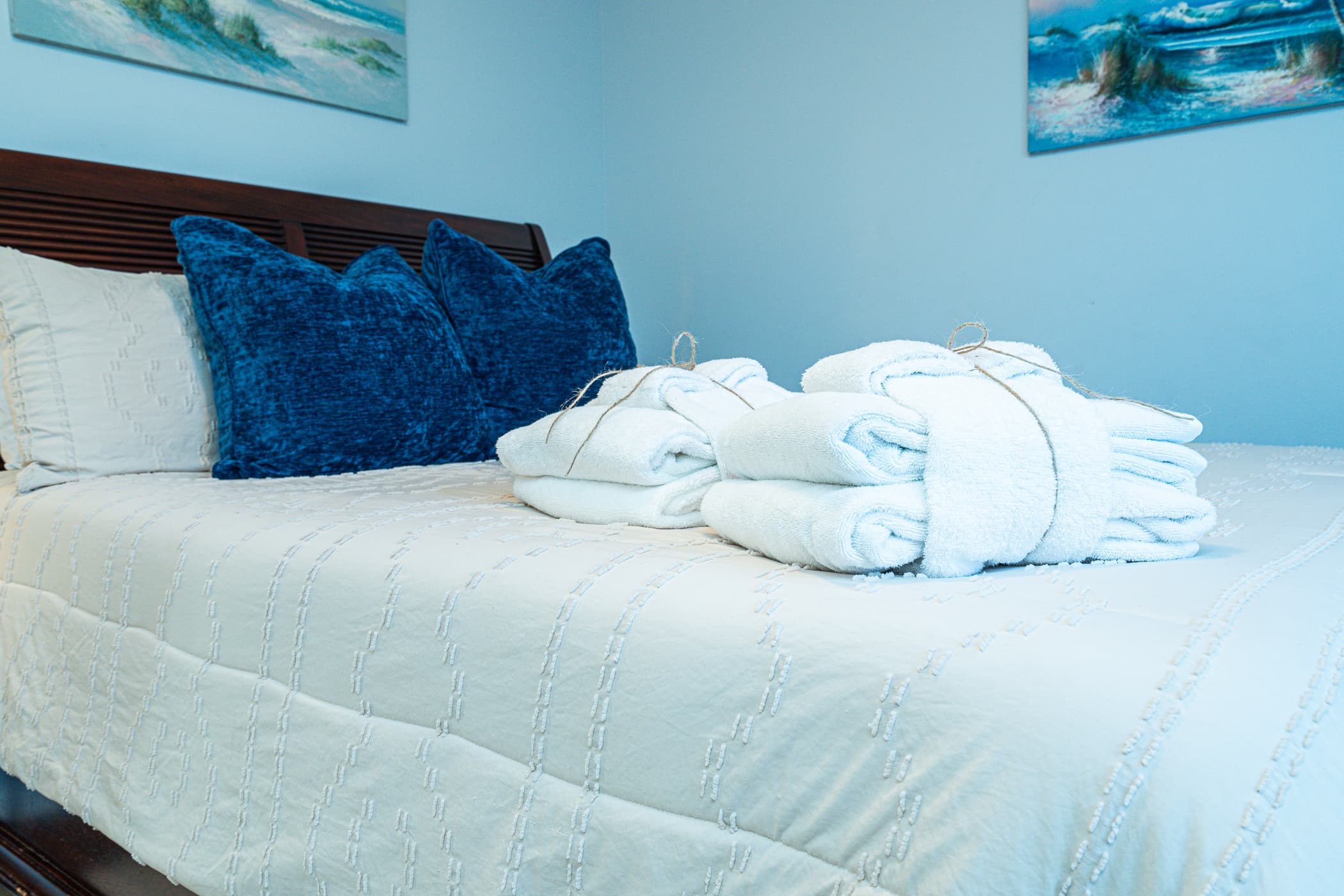 Bedroom Bliss: Plush pillows and fresh towels await in this beach-inspired sanctuary!