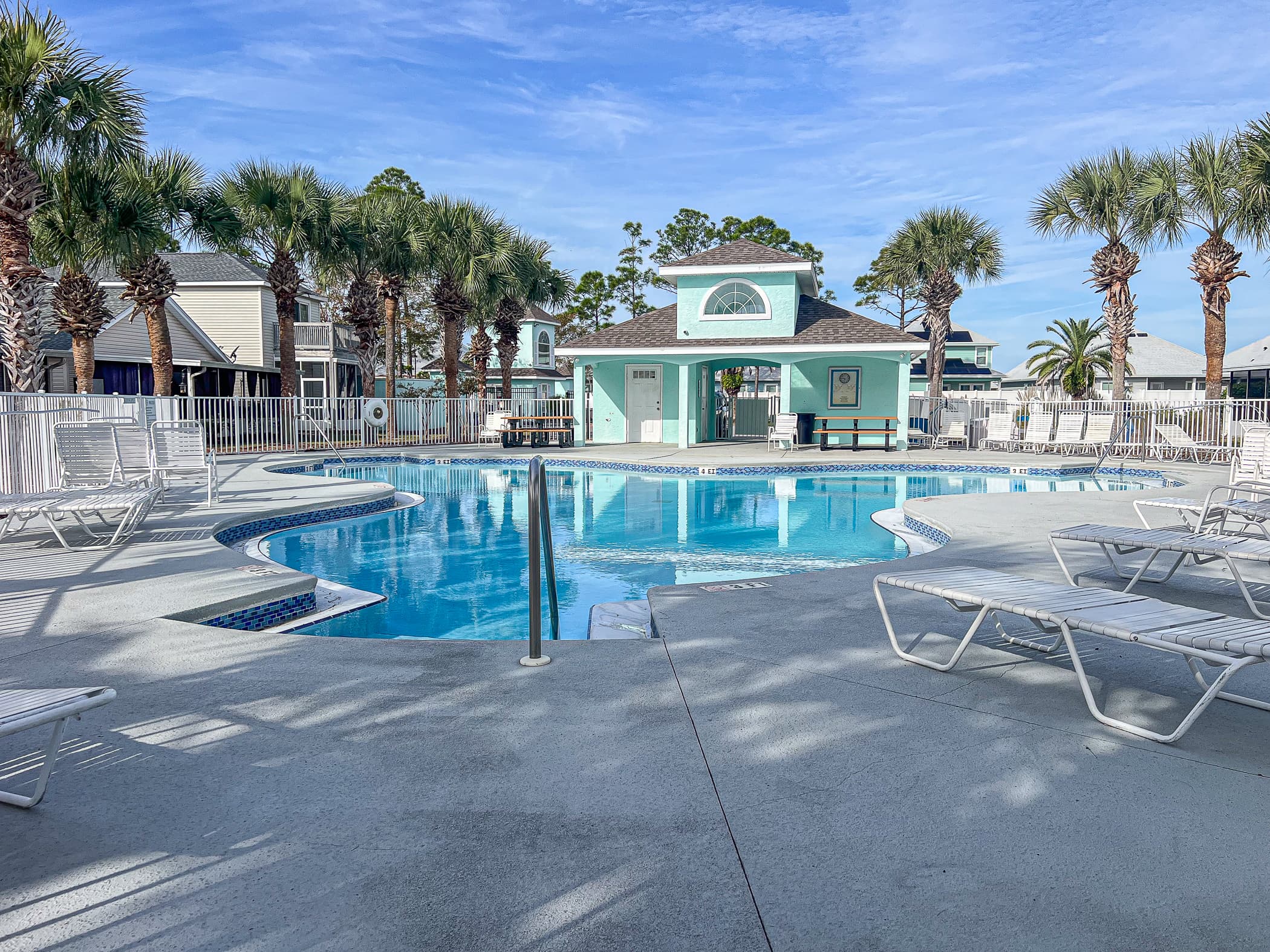 Community Pool Oasis: Dive into relaxation at this sparkling pool surrounded by palm trees!