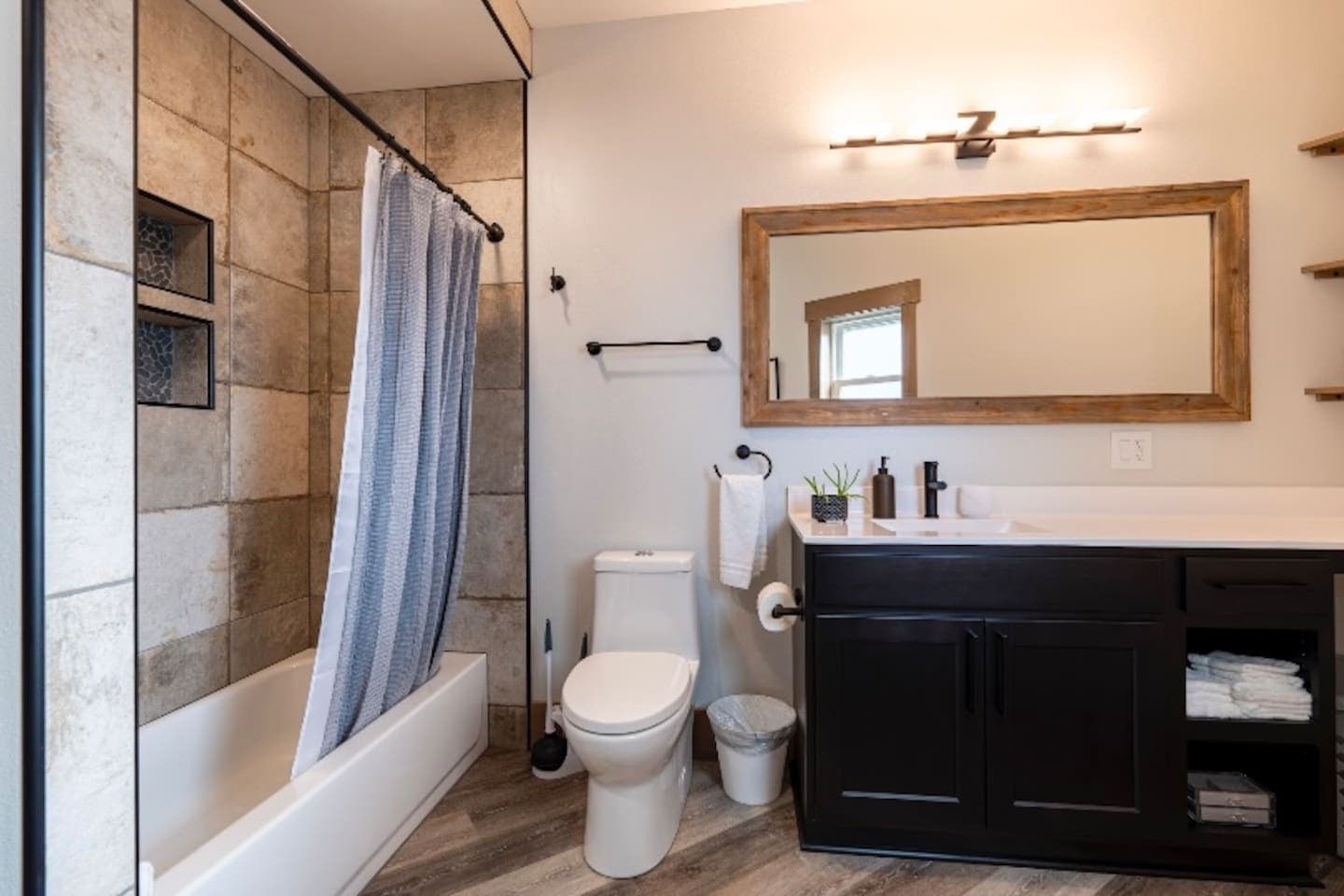 Bathroom 1 with custom tile shower with tub, toilet, and plenty of countertop space.