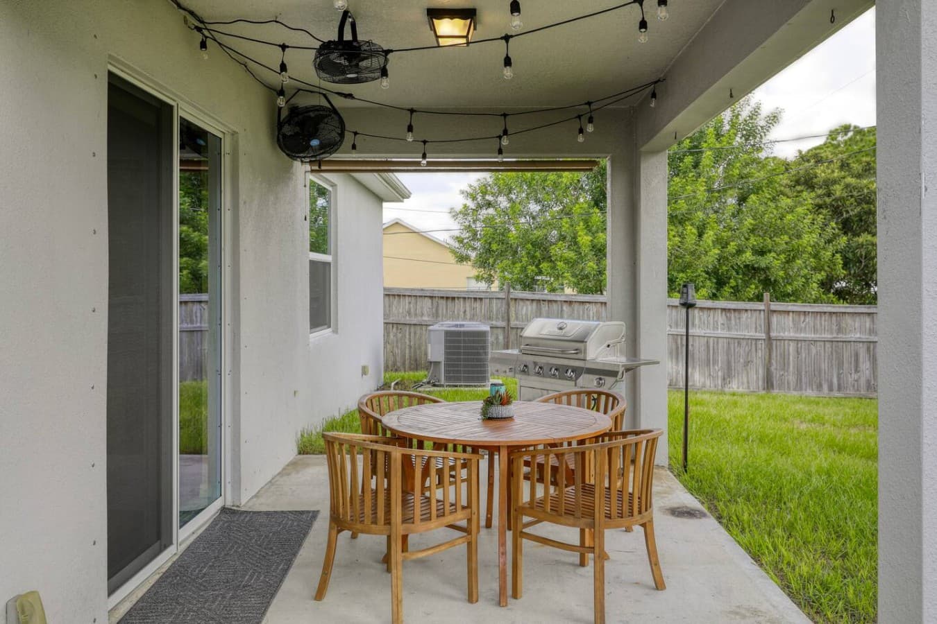 Dine outdoors on the covered patio, complete with seating for six, overhead fans, and a gas grill.