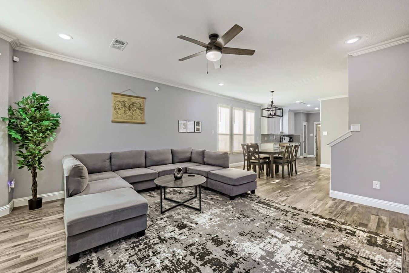 Spacious open-concept living room with oversized sectional seating and a seamless flow into the dining and kitchen areas.