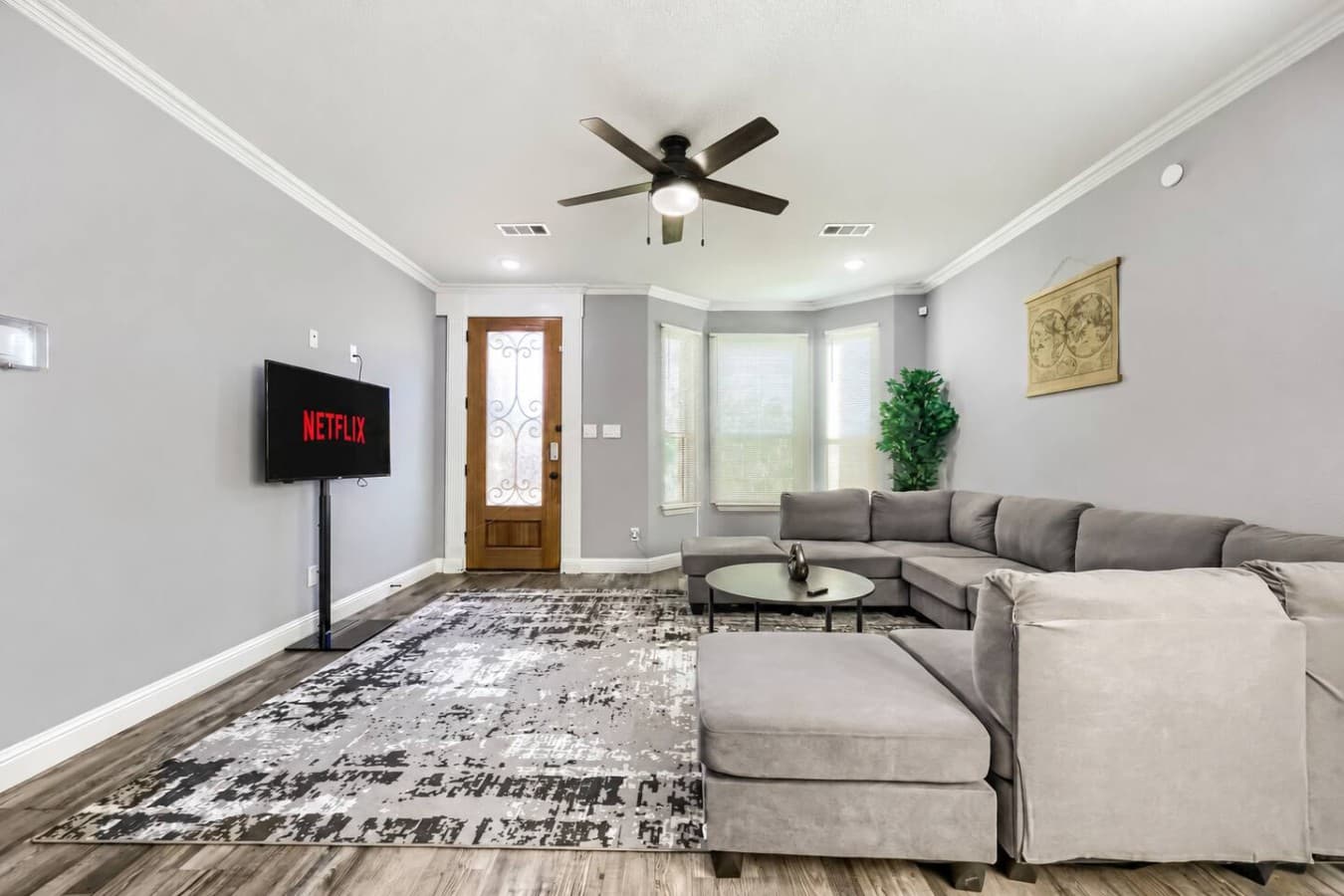 Settle in and make yourself comfortable in this spacious living room, complete with generous sectional seating and a dedicated entertainment area.