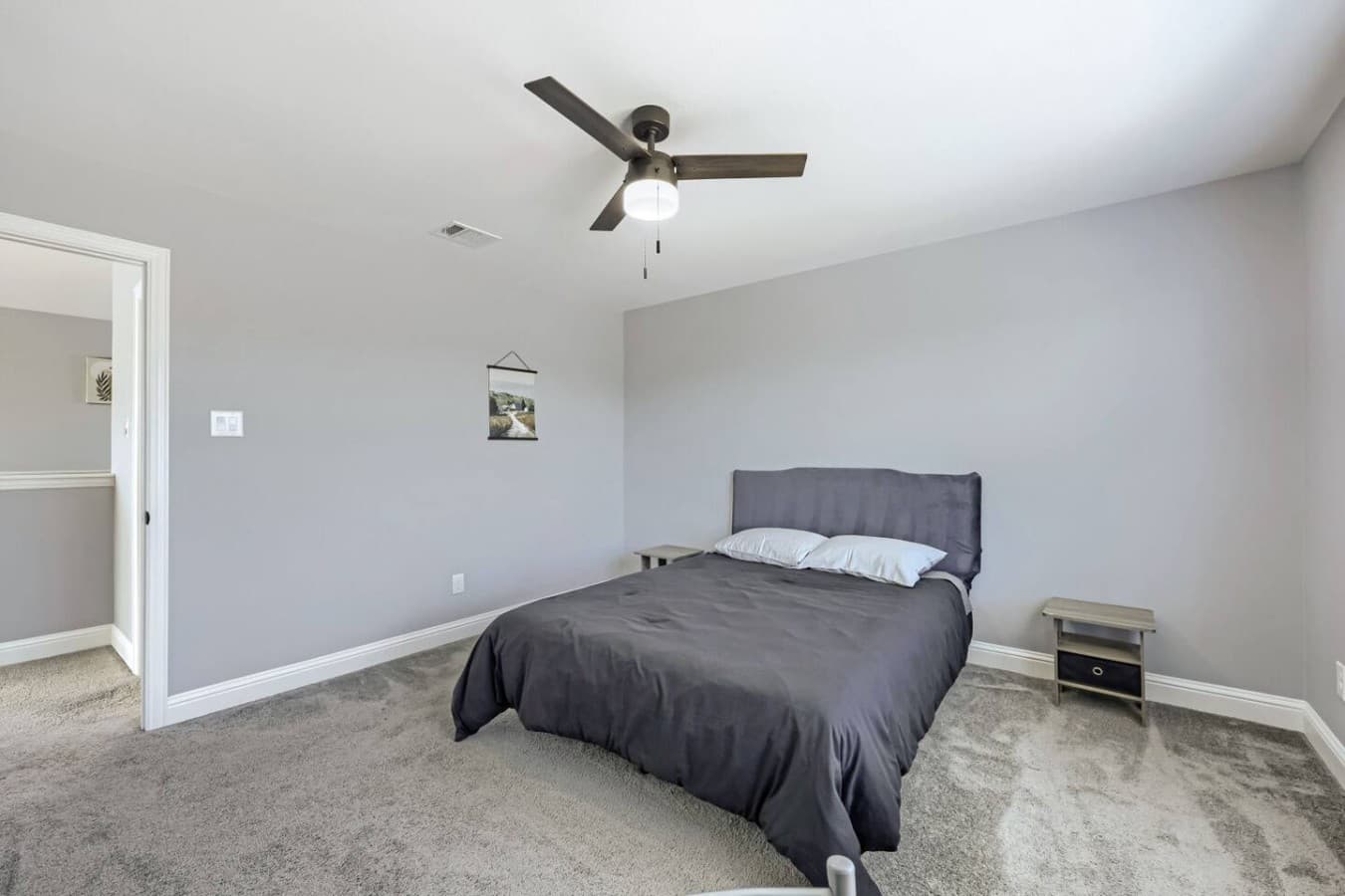This bedroom features a queen bed and a workstation for catching up on work.