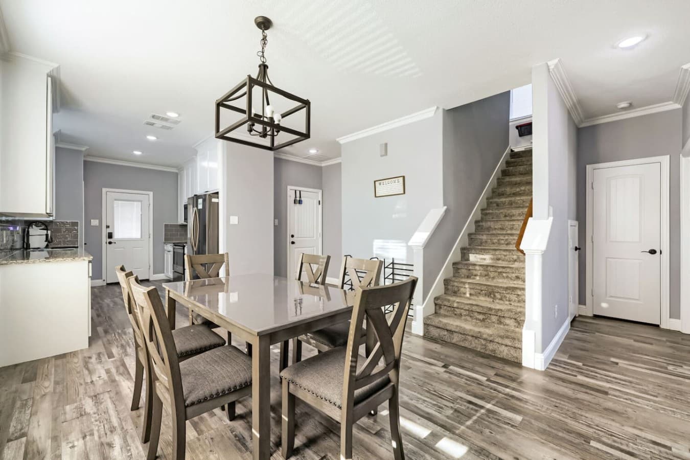 Large windows, classic cross-back chairs, and a statement chandelier create a welcoming setting for your next meal.