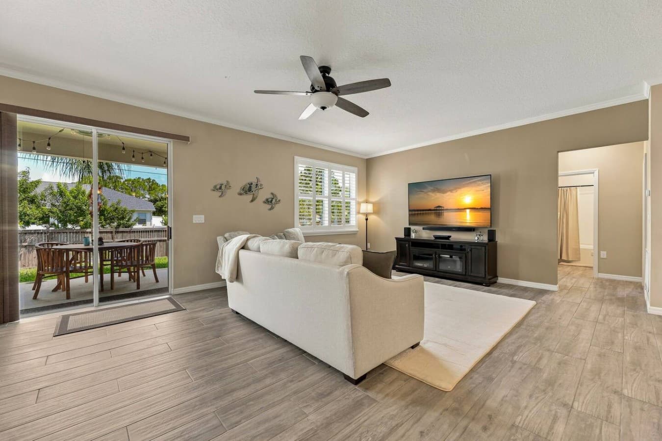 Gather for movie nights in this inviting living space, featuring ample seating, two additional chairs, a wall-mounted 75-inch TV, and kid-friendly games in the hutch behind the couch.