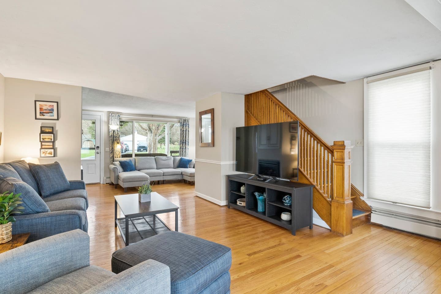 Living area with television beside the wooden handrail 