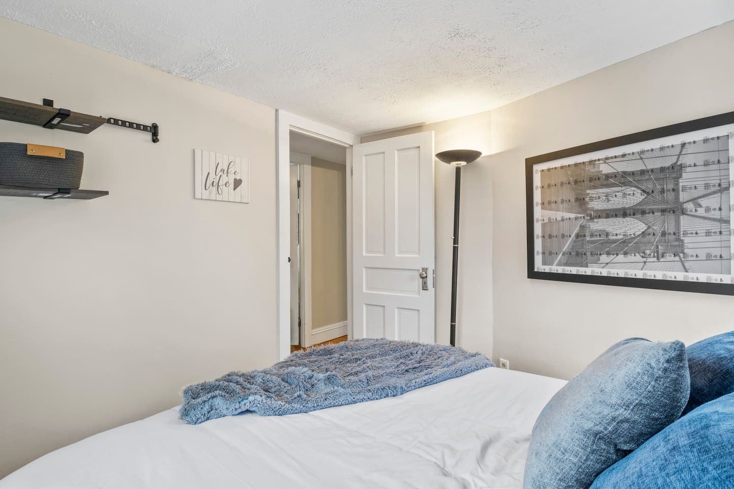 Bedroom with patterned bedding and huge artwork