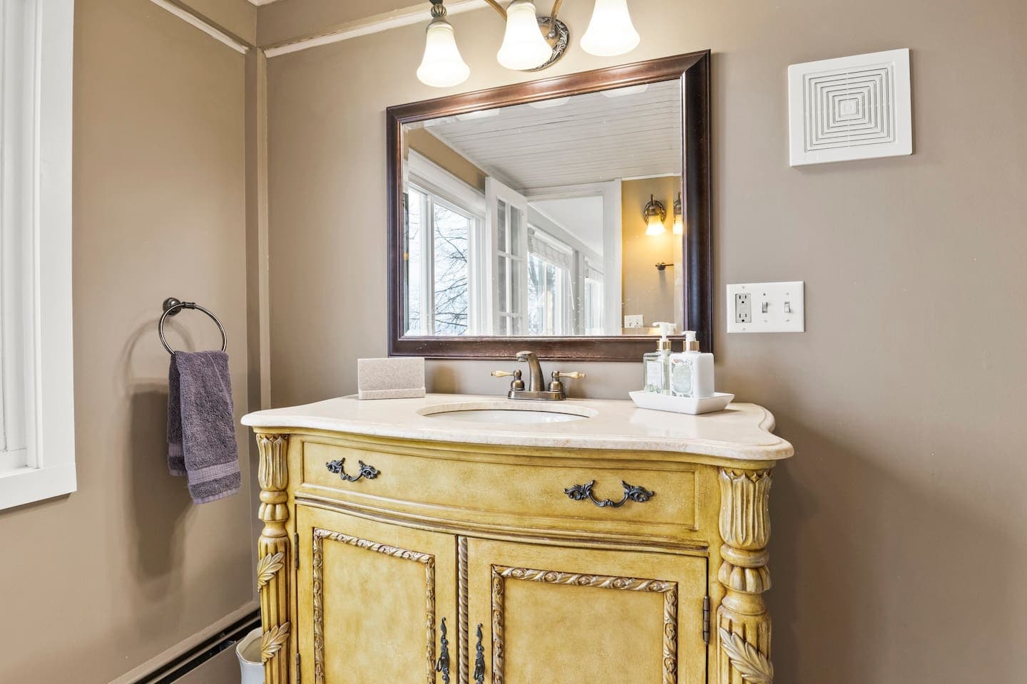 Bathroom with gold-toned vanity and large mirror