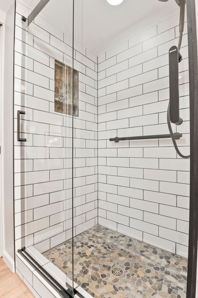 Walk-in shower with pebble tile flooring