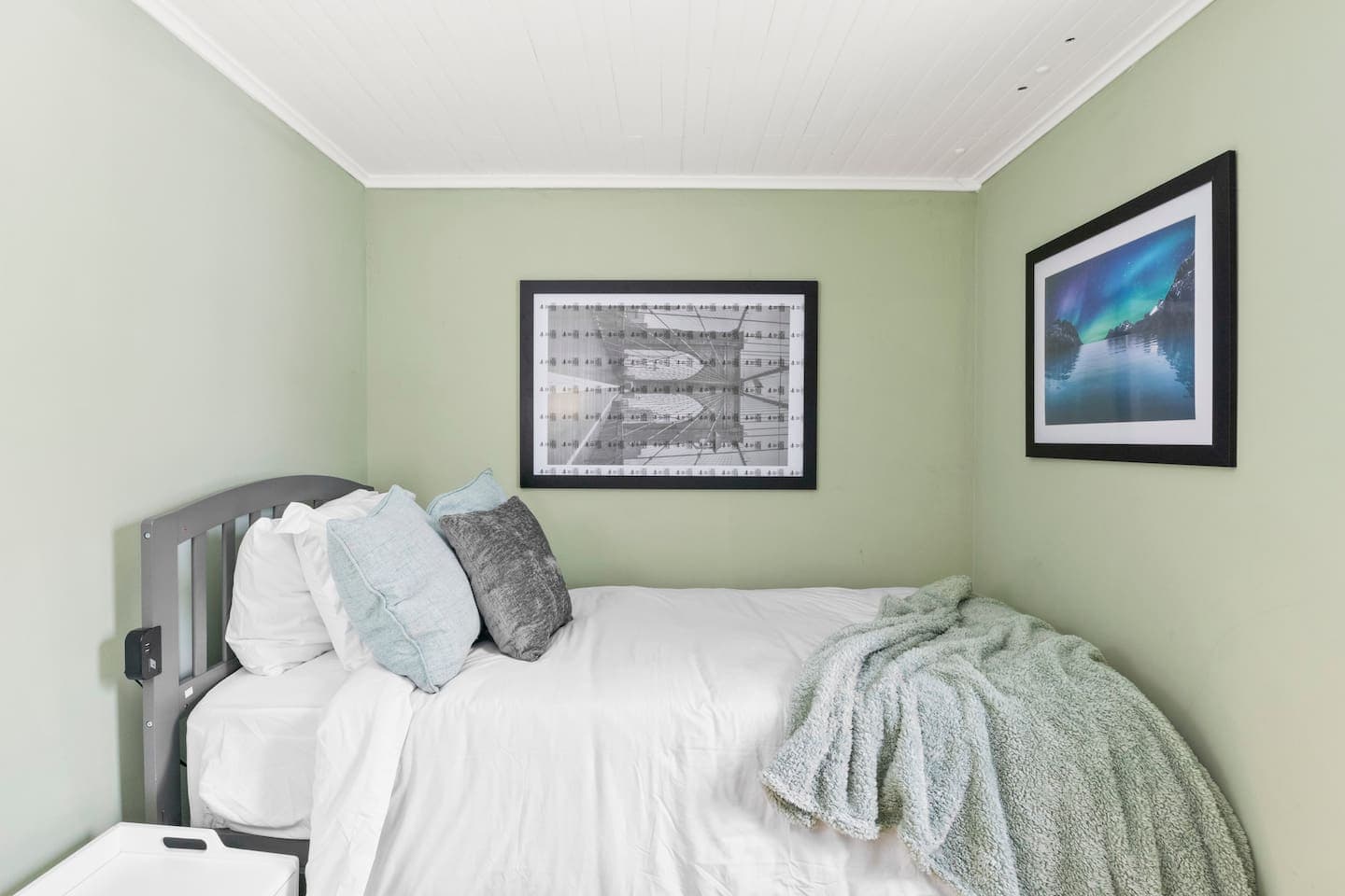 Bedroom with soft green walls and neutral bedding