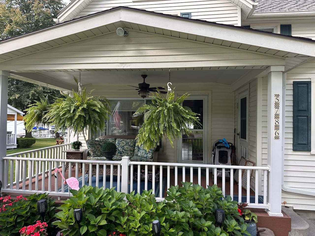 Covered porch with ceiling fan and hanging plants