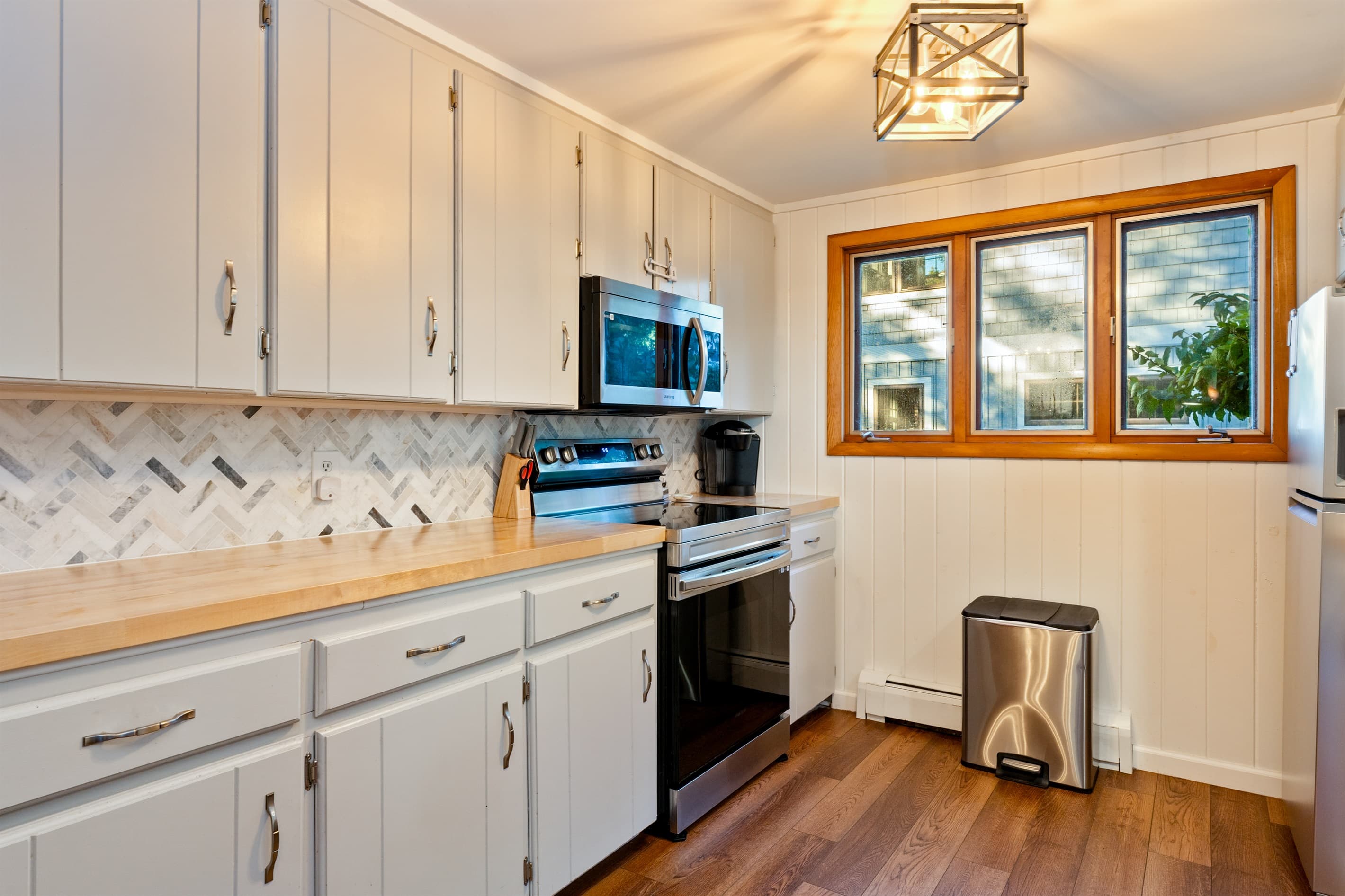 Kitchen workspace beneath three windows