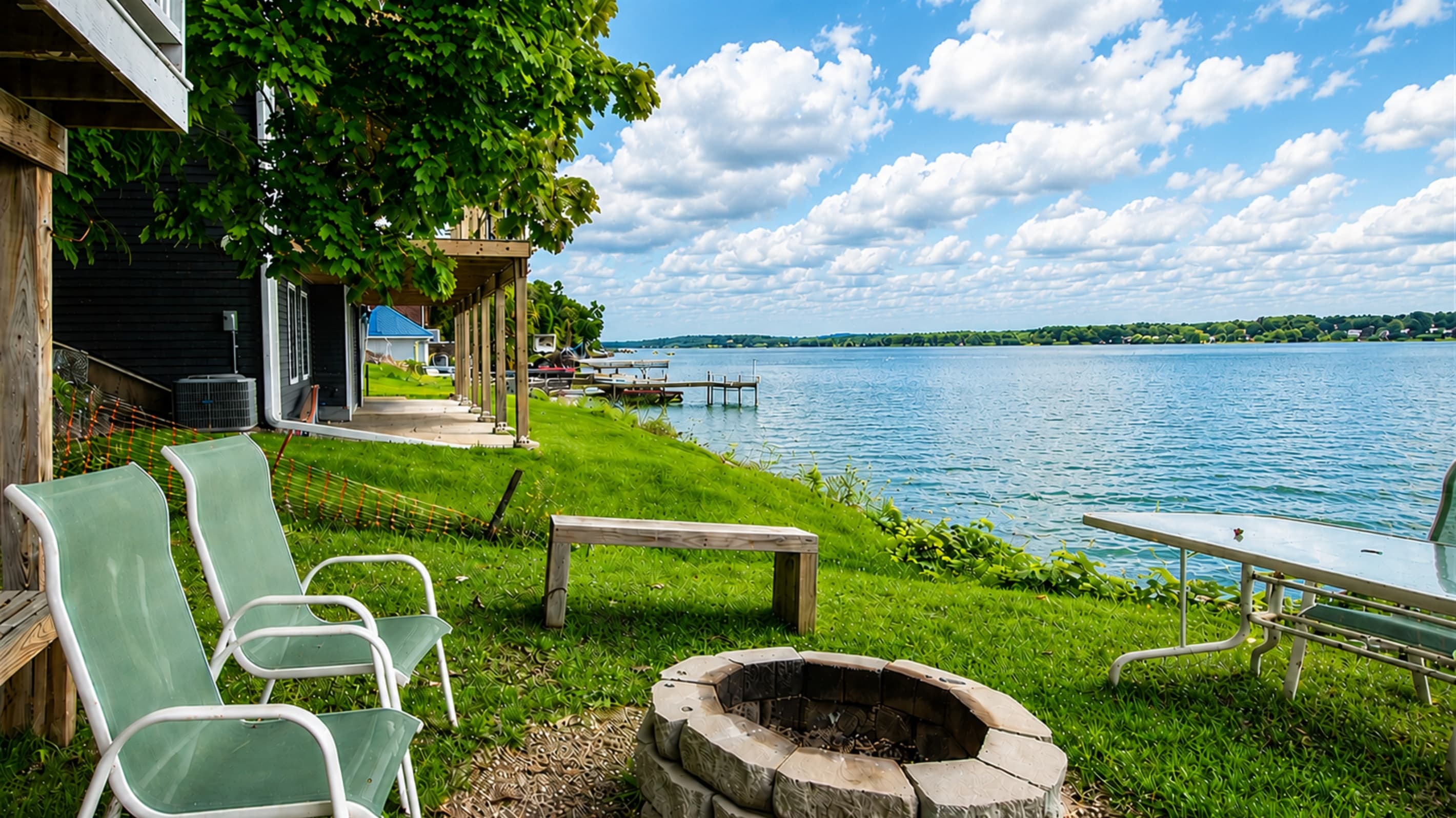 Grassy lakeside yard with Adirondack chairs