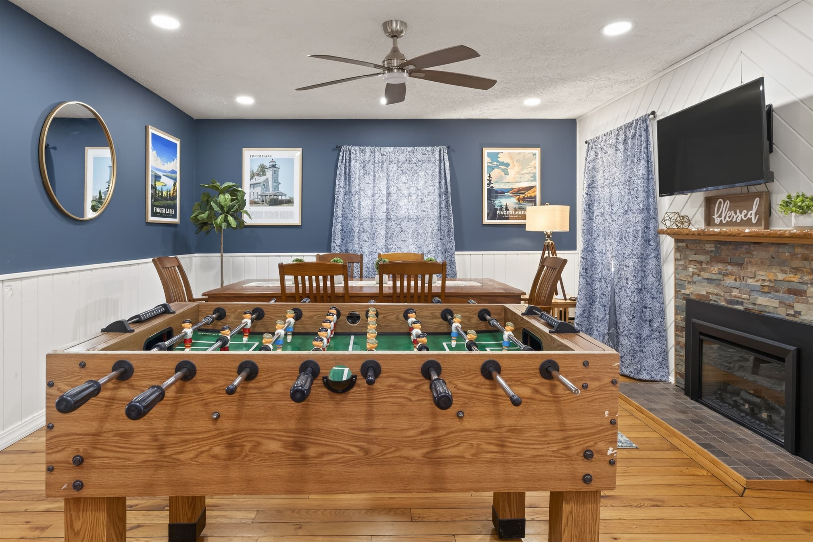 Foosball table in the living area with dining table and television 