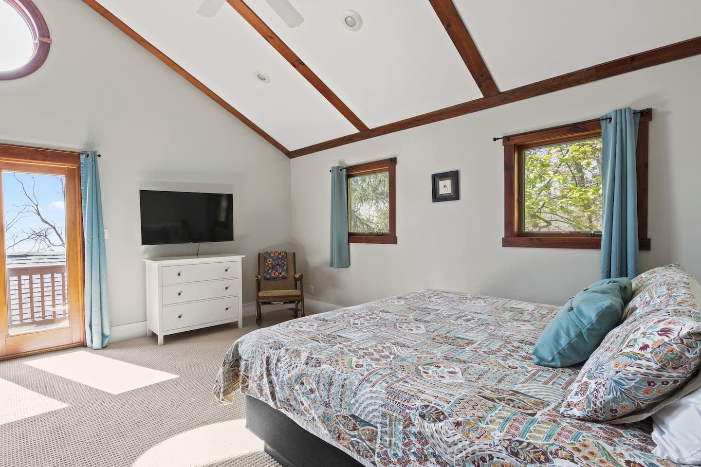 King bedroom with vaulted ceiling and television