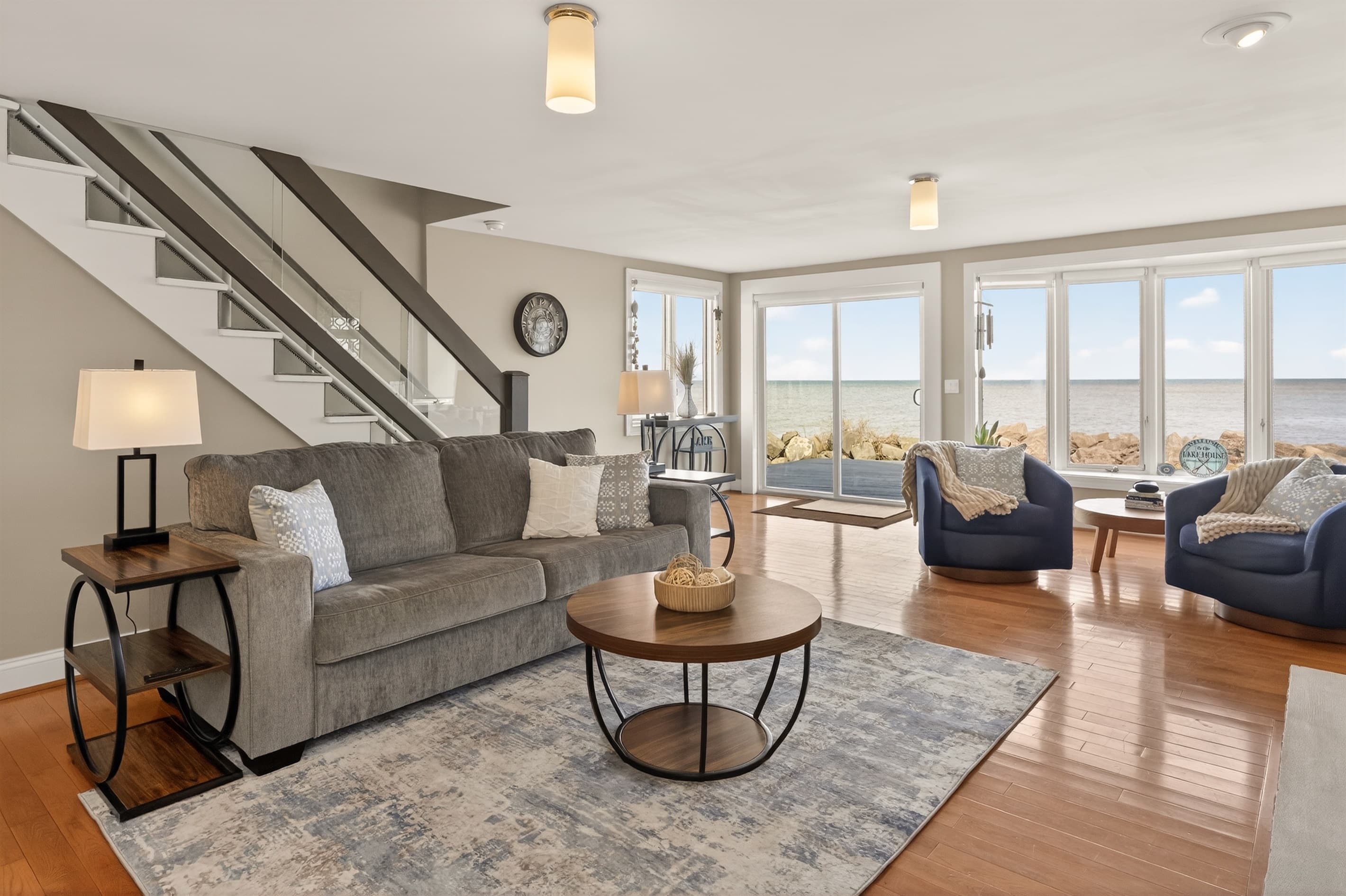 Living room with staircase and large windows